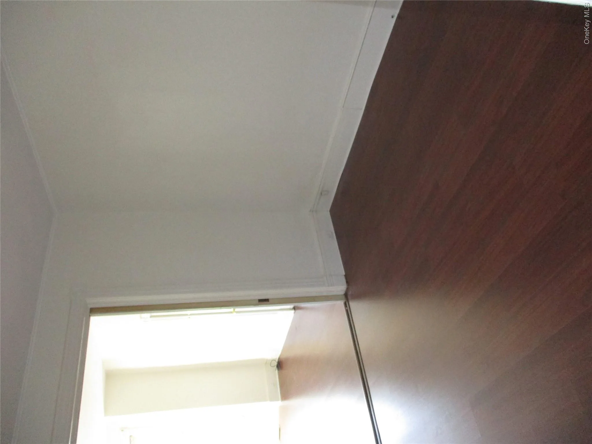 Unfurnished room with dark wood-style floors and crown molding Unfurnished room with dark wood-style floors and crown molding