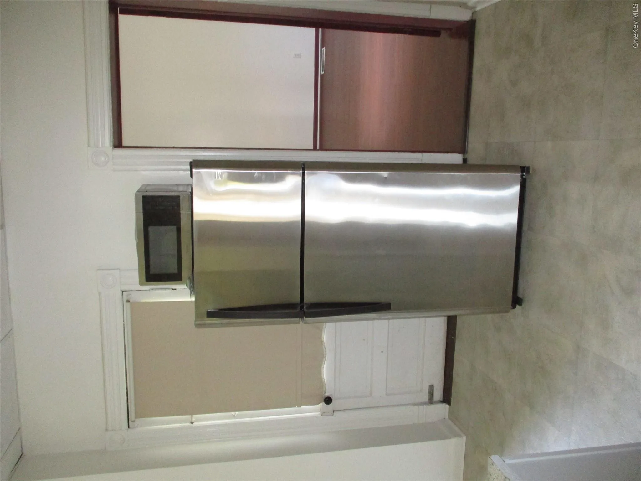 Kitchen featuring freestanding refrigerator, white cabinets, and light floors Kitchen featuring freestanding refrigerator, white cabinets, and light floors