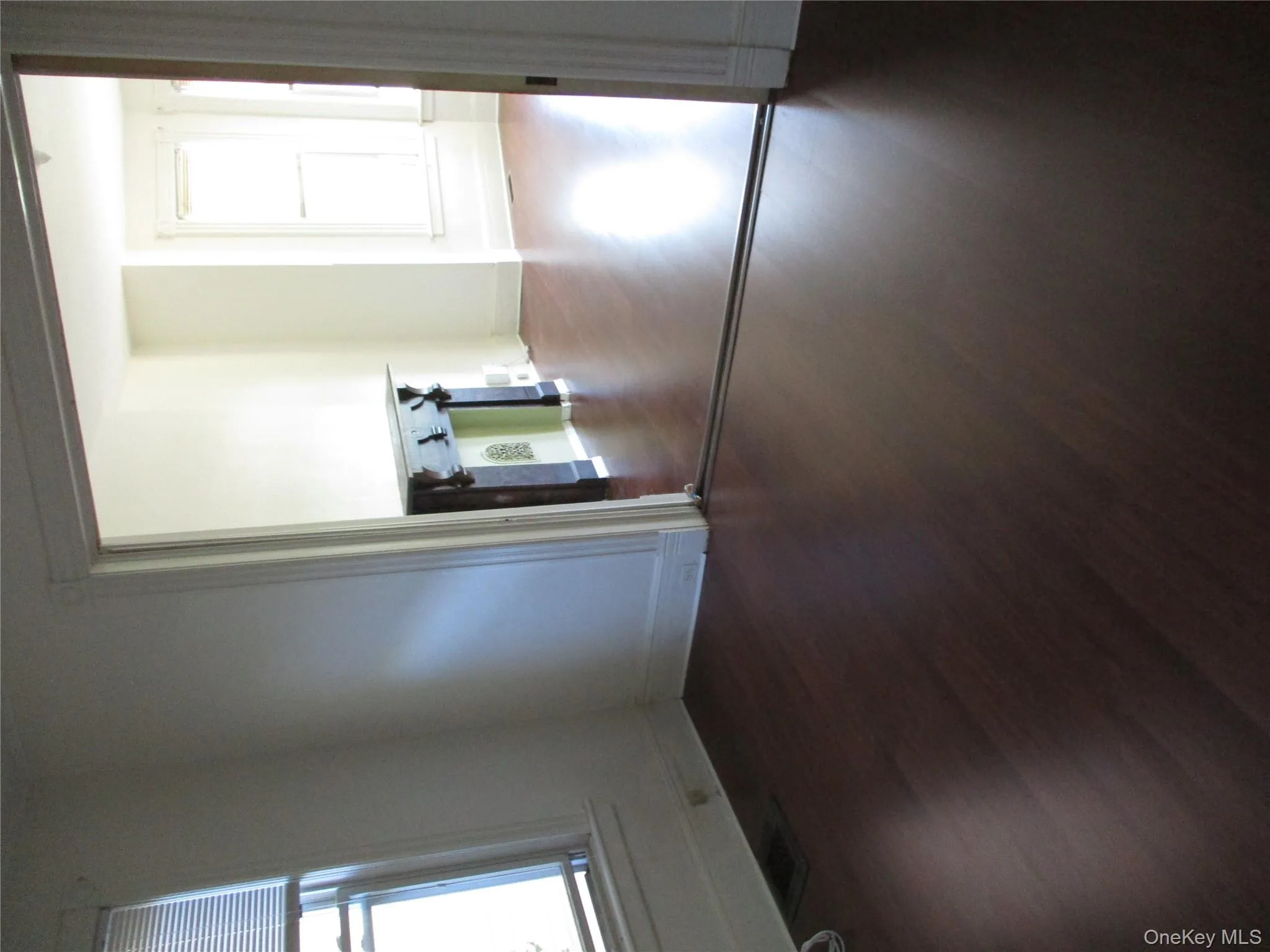 Spare room featuring healthy amount of natural light and dark wood-style floors Spare room featuring healthy amount of natural light and dark wood-style floors