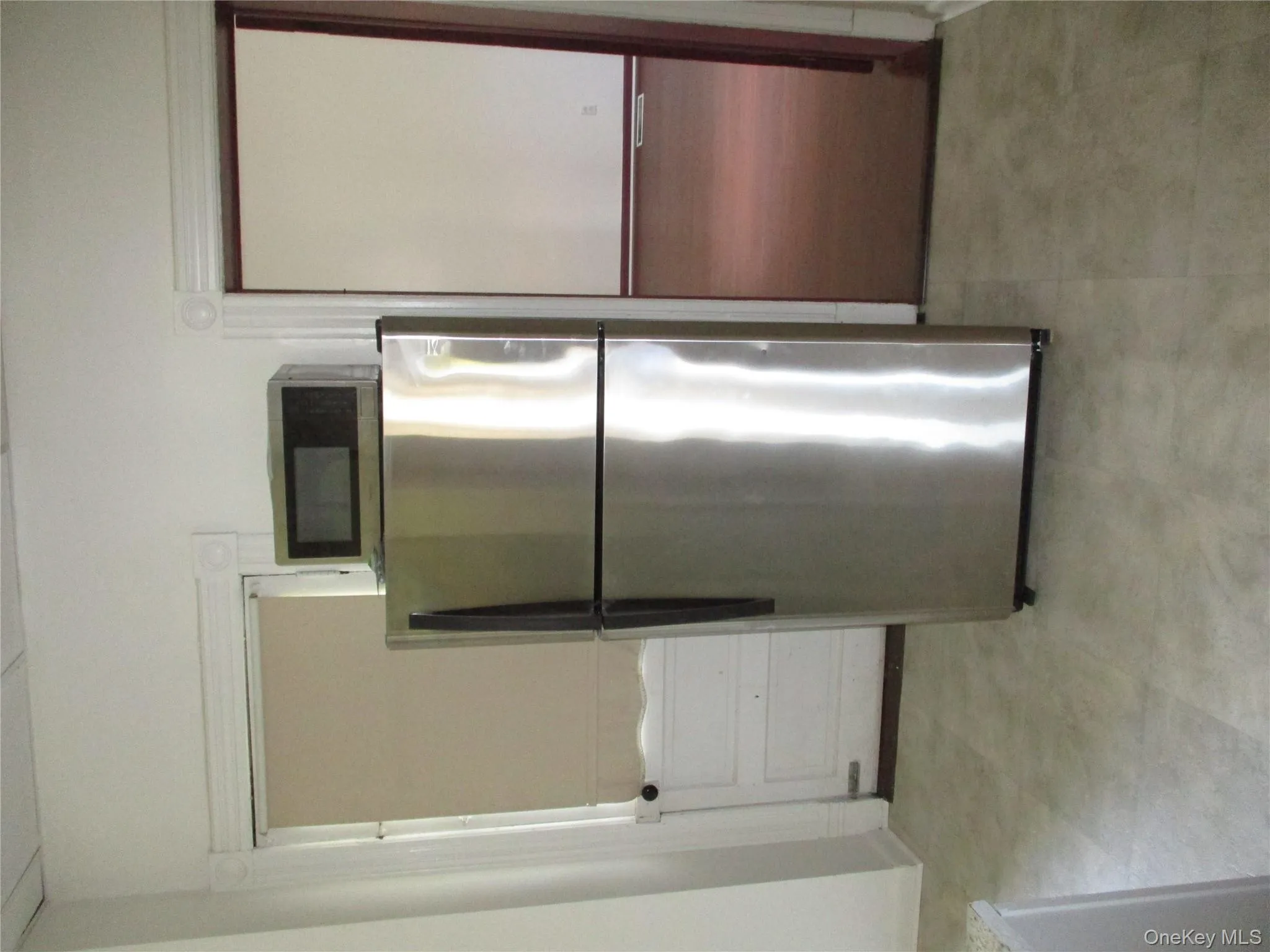 Kitchen featuring freestanding refrigerator, white cabinets, and light floors Kitchen featuring freestanding refrigerator, white cabinets, and light floors