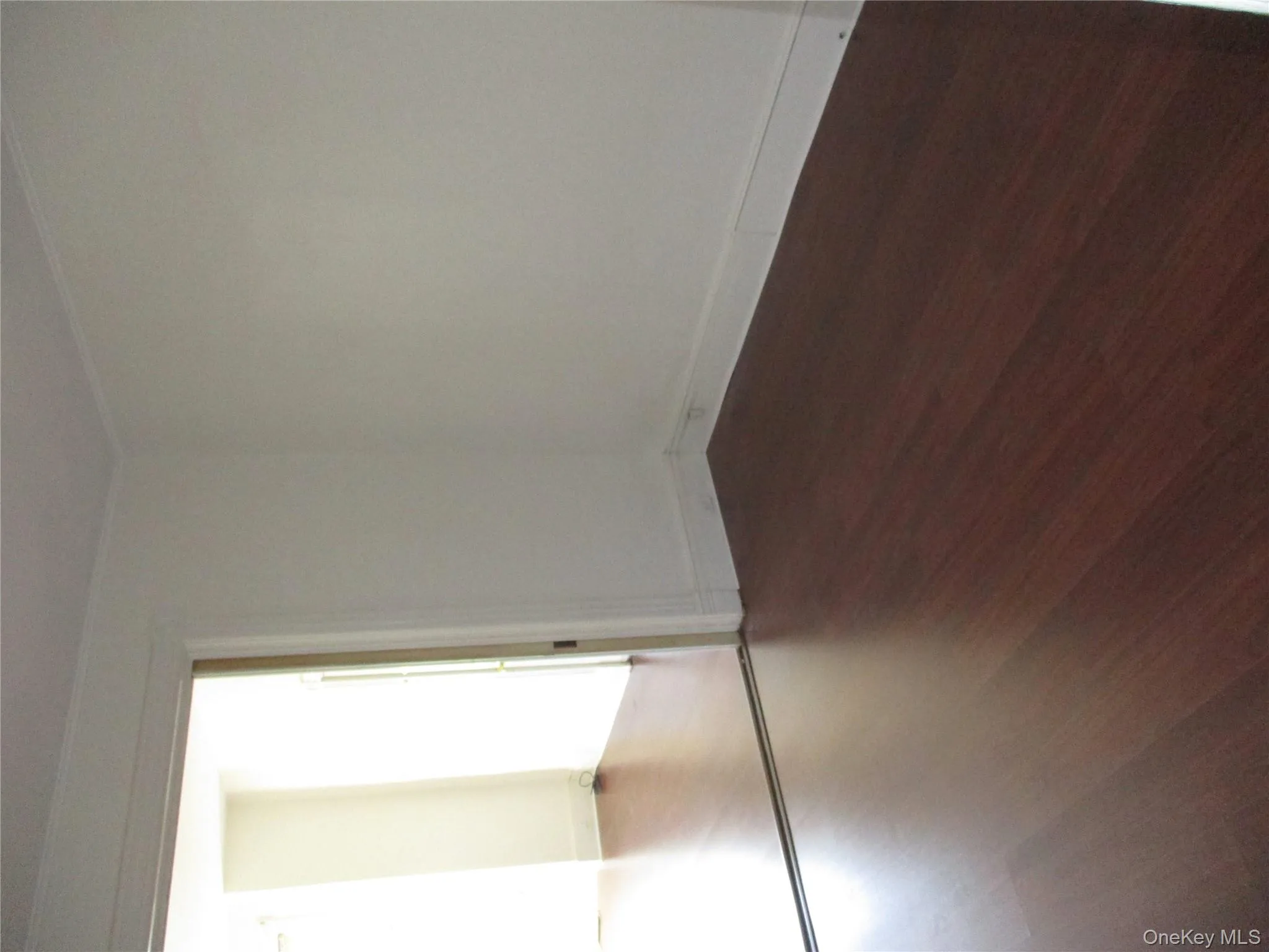 Unfurnished room with dark wood-style floors and crown molding Unfurnished room with dark wood-style floors and crown molding