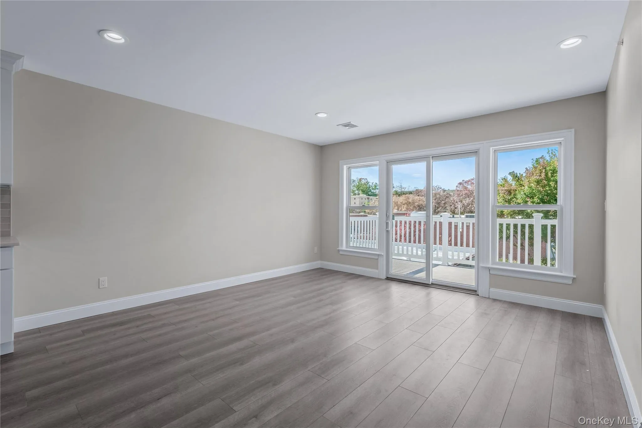 Unfurnished living room with wood finished floors and recessed lighting Unfurnished living room with wood finished floors and recessed lighting