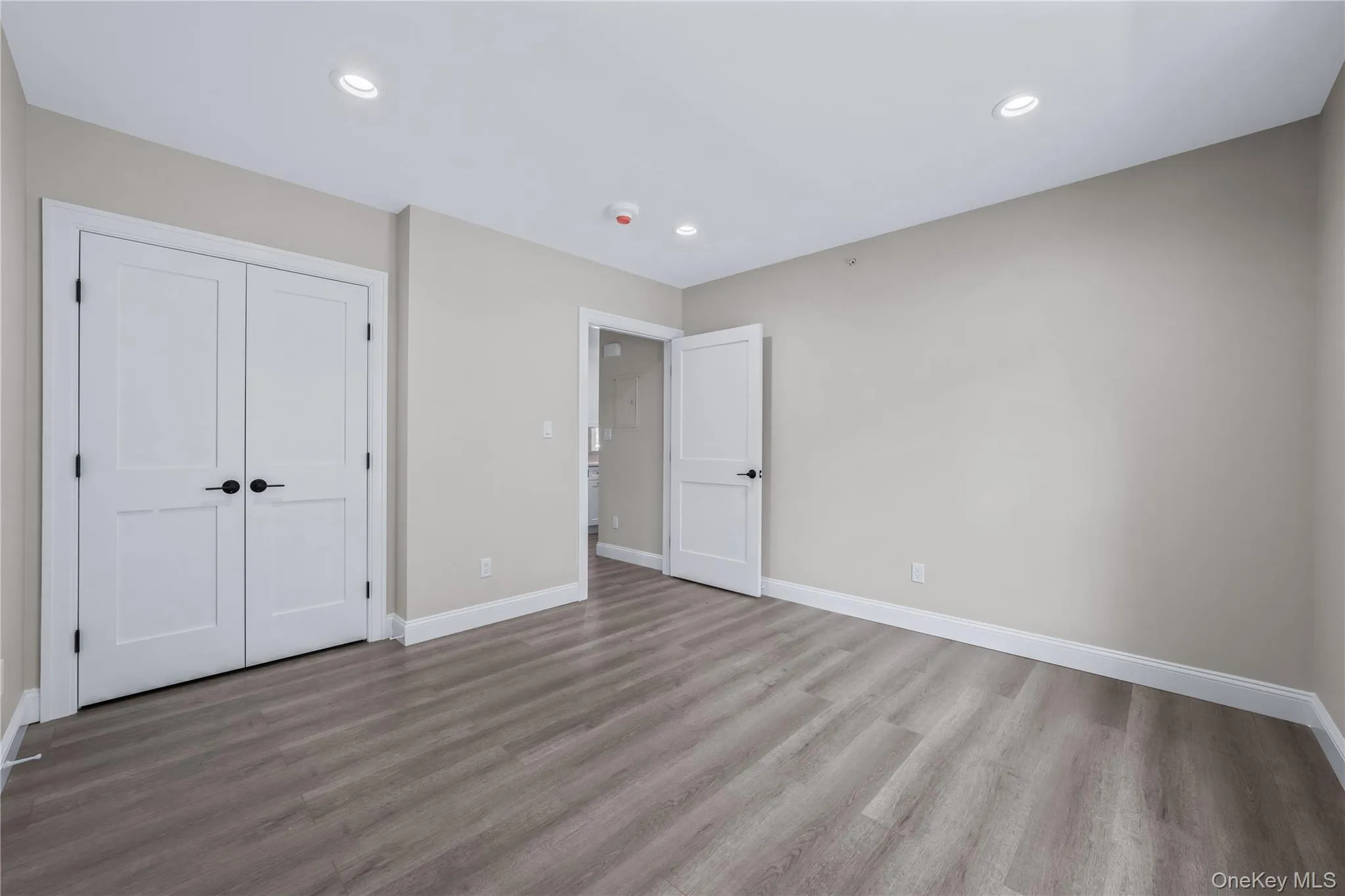 Unfurnished bedroom with wood finished floors, a closet, and recessed lighting Unfurnished bedroom with wood finished floors, a closet, and recessed lighting