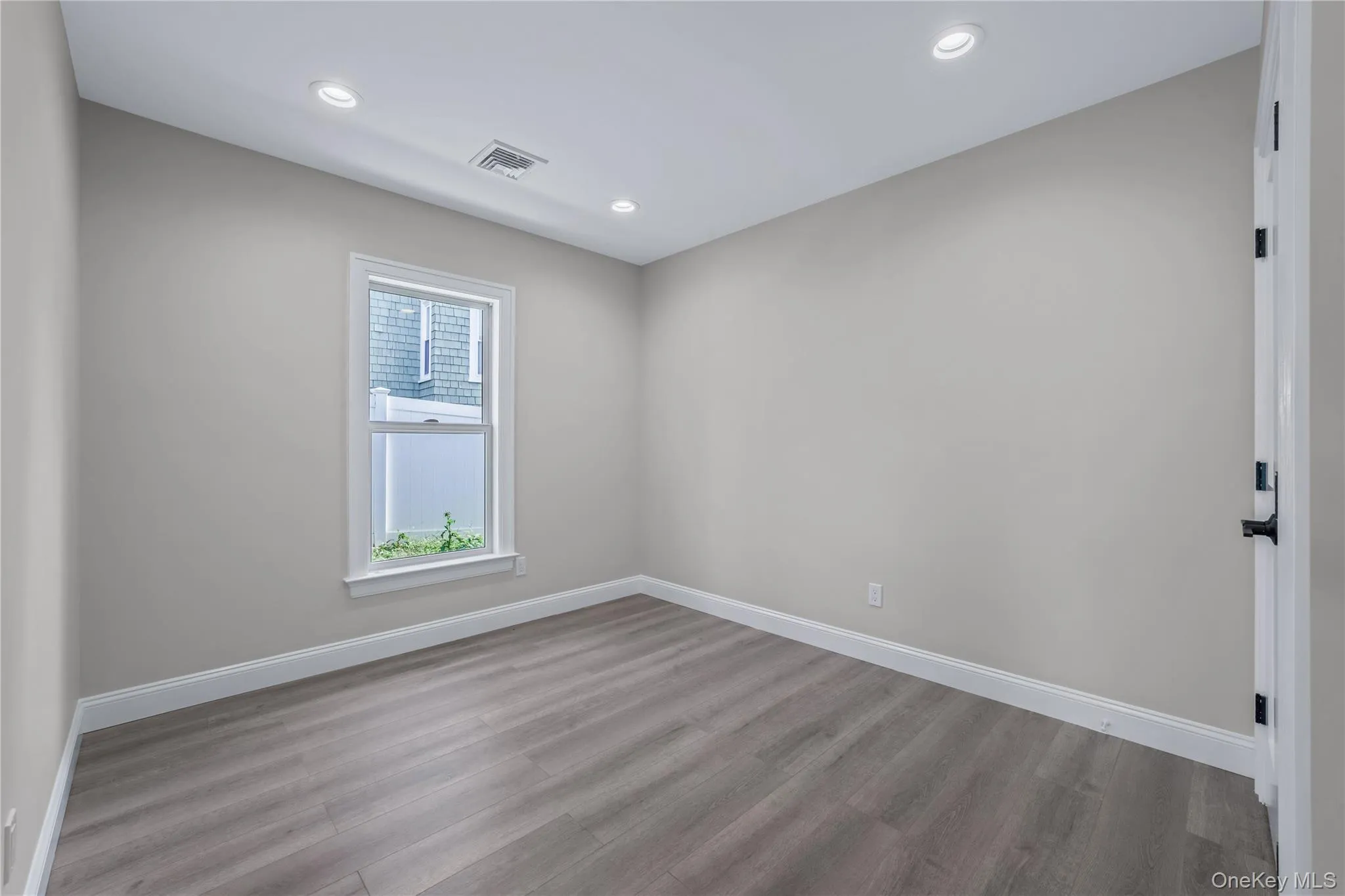 Empty room featuring wood finished floors and recessed lighting Empty room featuring wood finished floors and recessed lighting