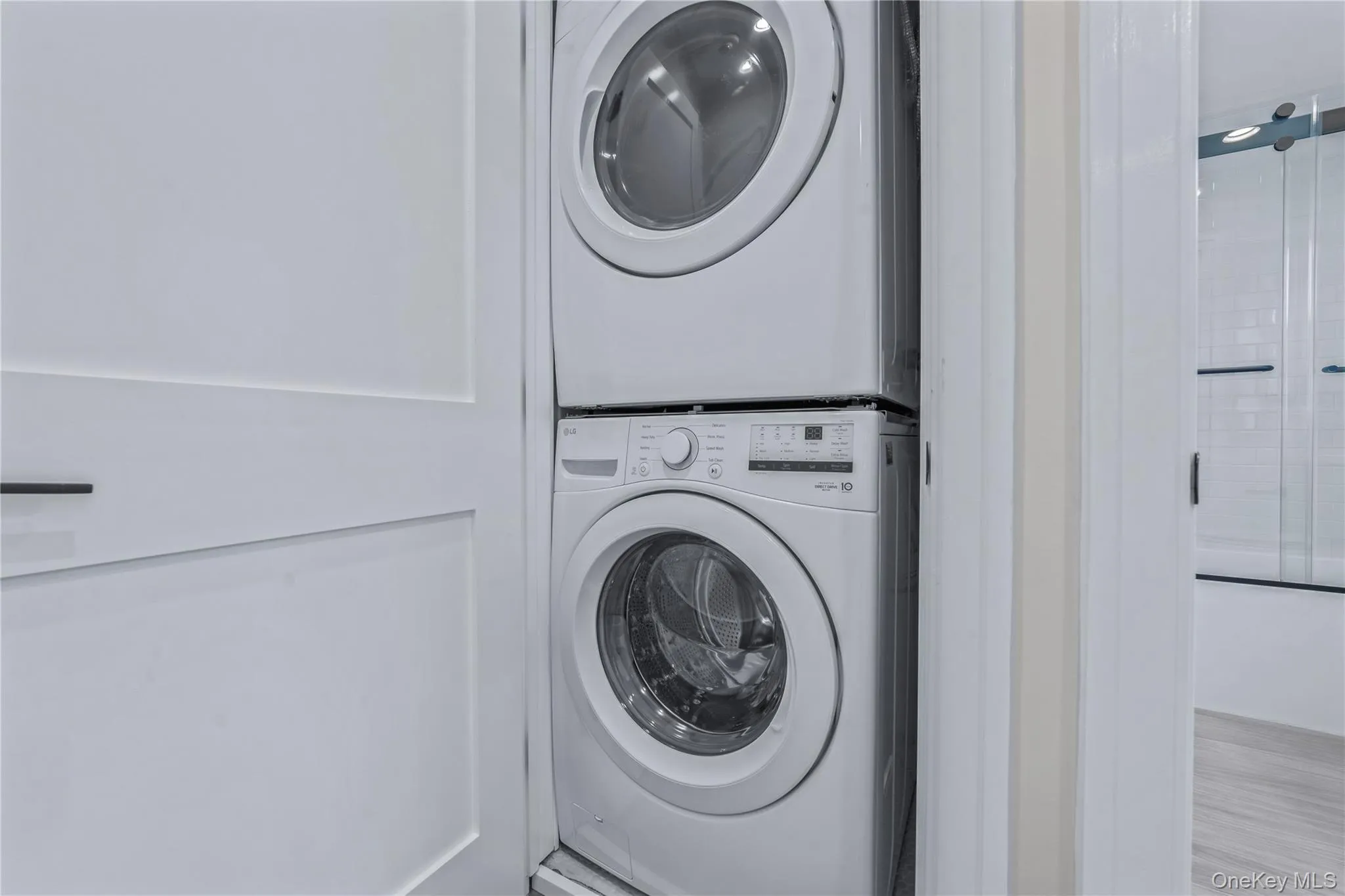 Washroom featuring stacked washer / drying machine Washroom featuring stacked washer / drying machine