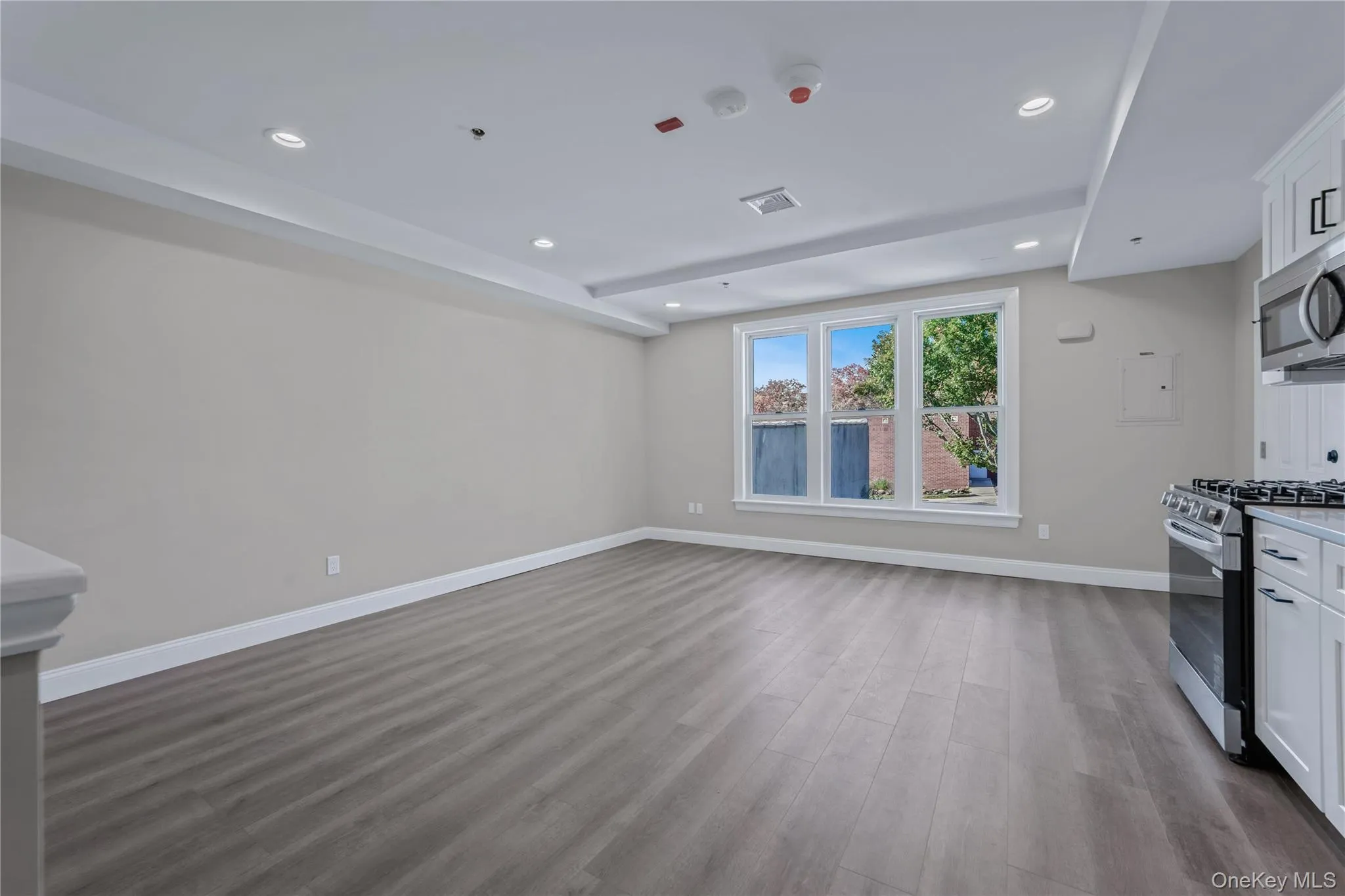 Kitchen with white cabinets, appliances with stainless steel finishes, light wood-style flooring, recessed lighting, and open floor plan Kitchen with white cabinets, appliances with stainless steel finishes, light wood-style flooring, recessed lighting, and open floor plan