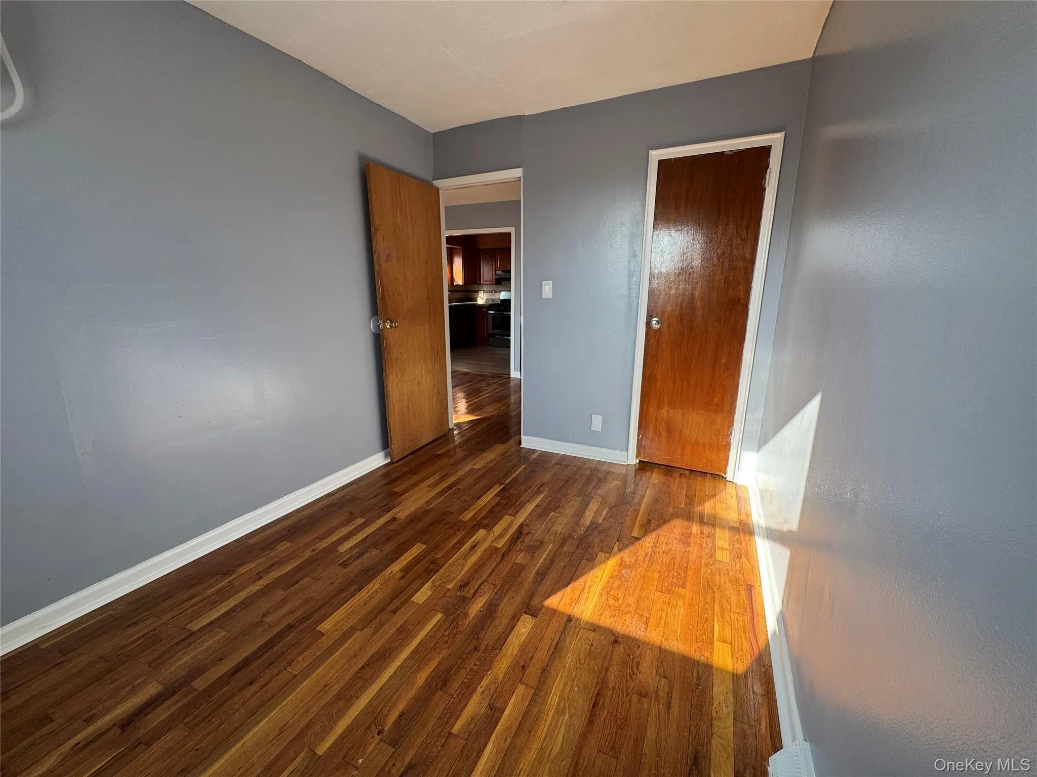 Unfurnished bedroom featuring dark wood-style floors and a closet Unfurnished bedroom featuring dark wood-style floors and a closet