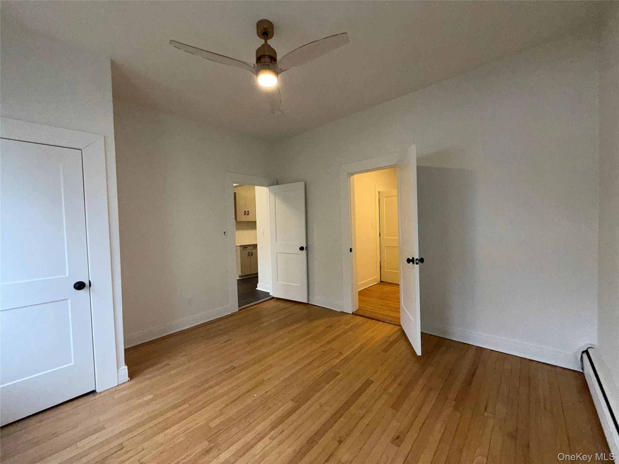 Unfurnished bedroom with baseboard heating and light wood-type flooring Unfurnished bedroom with baseboard heating and light wood-type flooring
