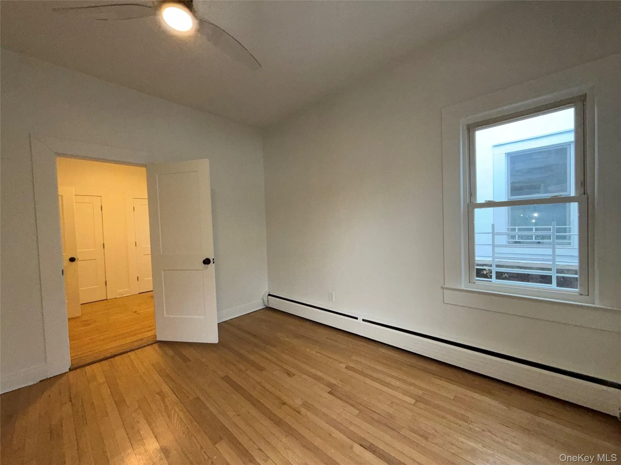 Spare room featuring a baseboard heating unit, light wood-style flooring, and ceiling fan Spare room featuring a baseboard heating unit, light wood-style flooring, and ceiling fan