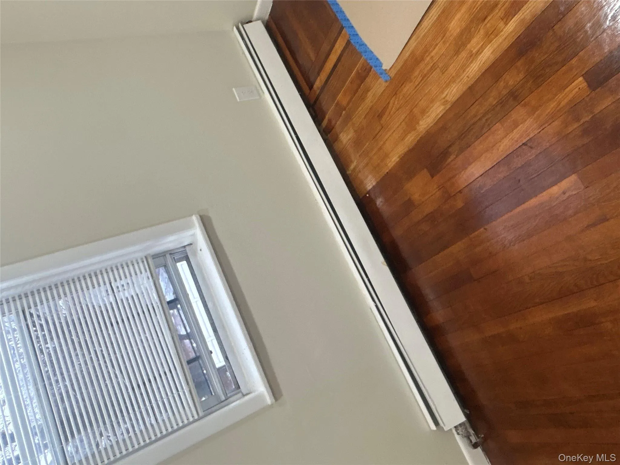 Detailed view of a baseboard heating unit and wood finished floors Detailed view of a baseboard heating unit and wood finished floors