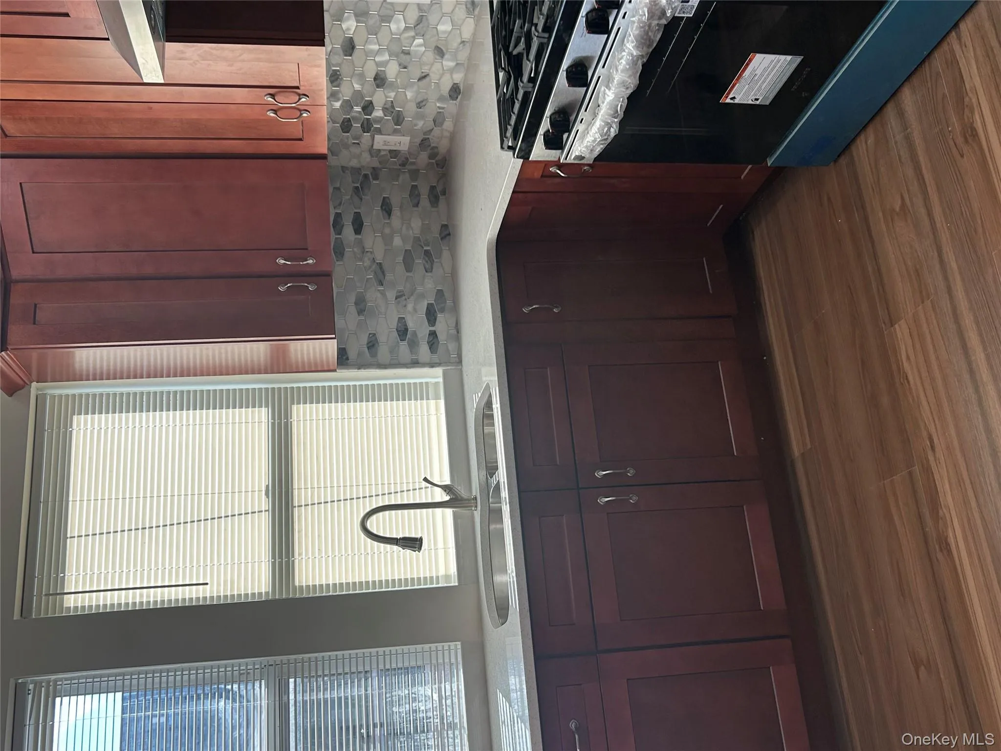 Kitchen with range, extractor fan, tasteful backsplash, dark wood finished floors, and light stone counters Kitchen with range, extractor fan, tasteful backsplash, dark wood finished floors, and light stone counters