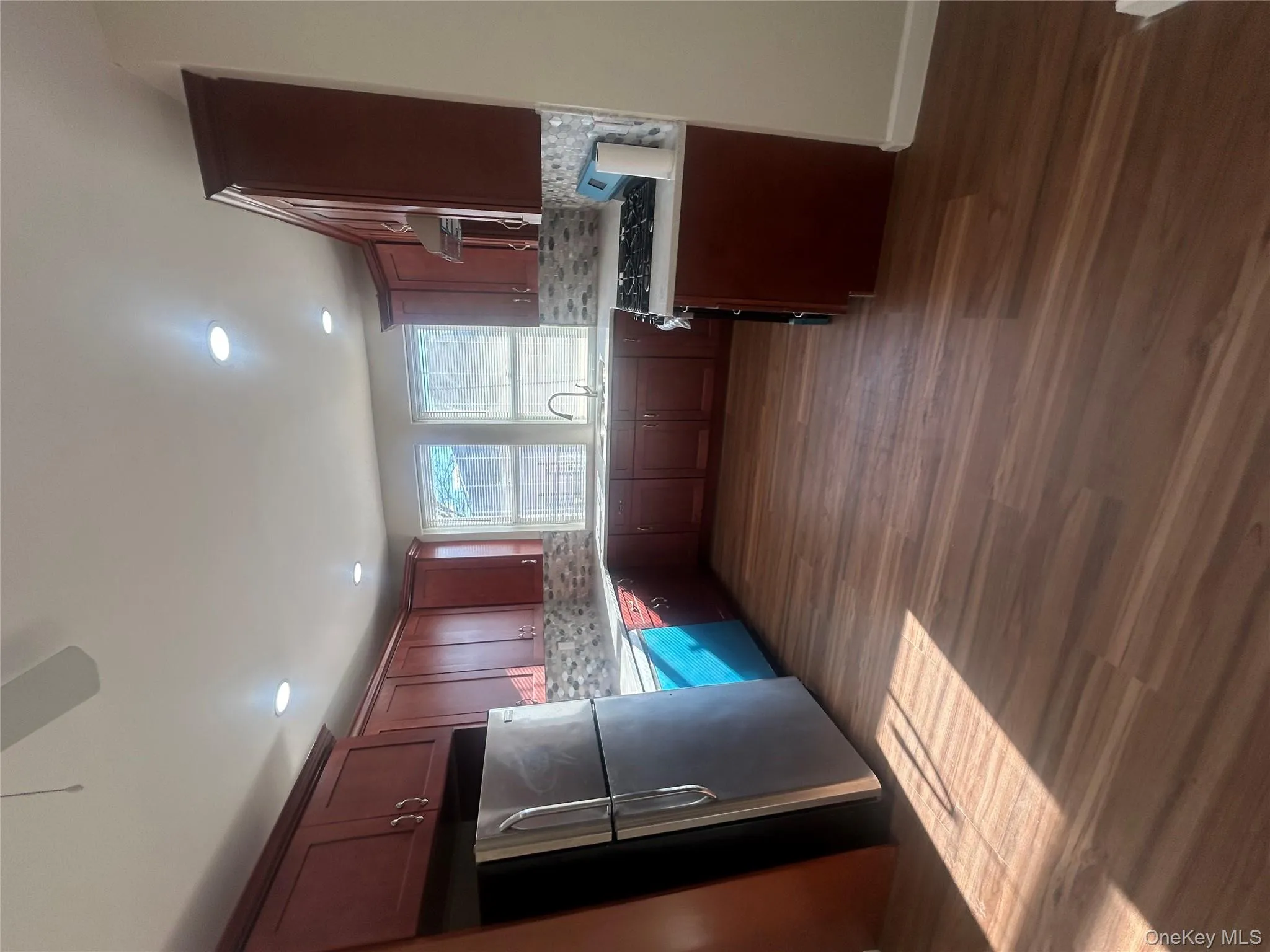 Kitchen featuring fridge, range, light countertops, dark wood-style flooring, and backsplash Kitchen featuring fridge, range, light countertops, dark wood-style flooring, and backsplash