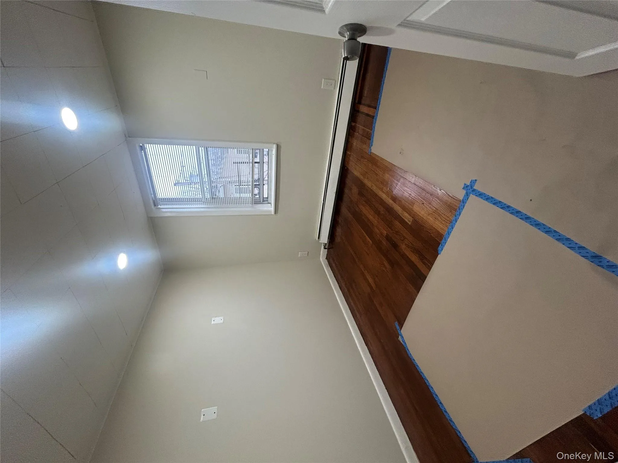 Unfurnished room with dark wood-style floors and baseboard heating Unfurnished room with dark wood-style floors and baseboard heating