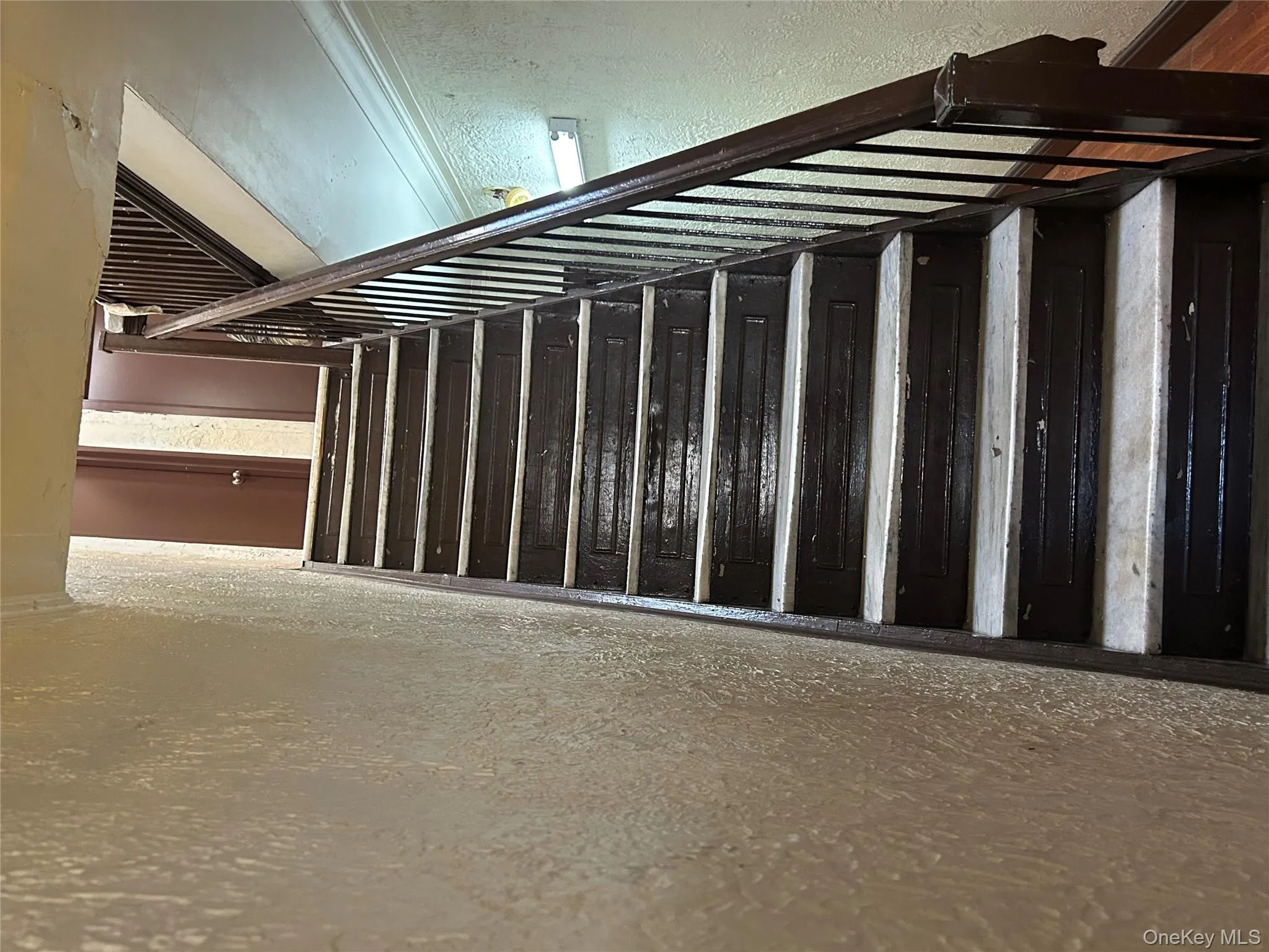 Stairway featuring a textured wall Stairway featuring a textured wall