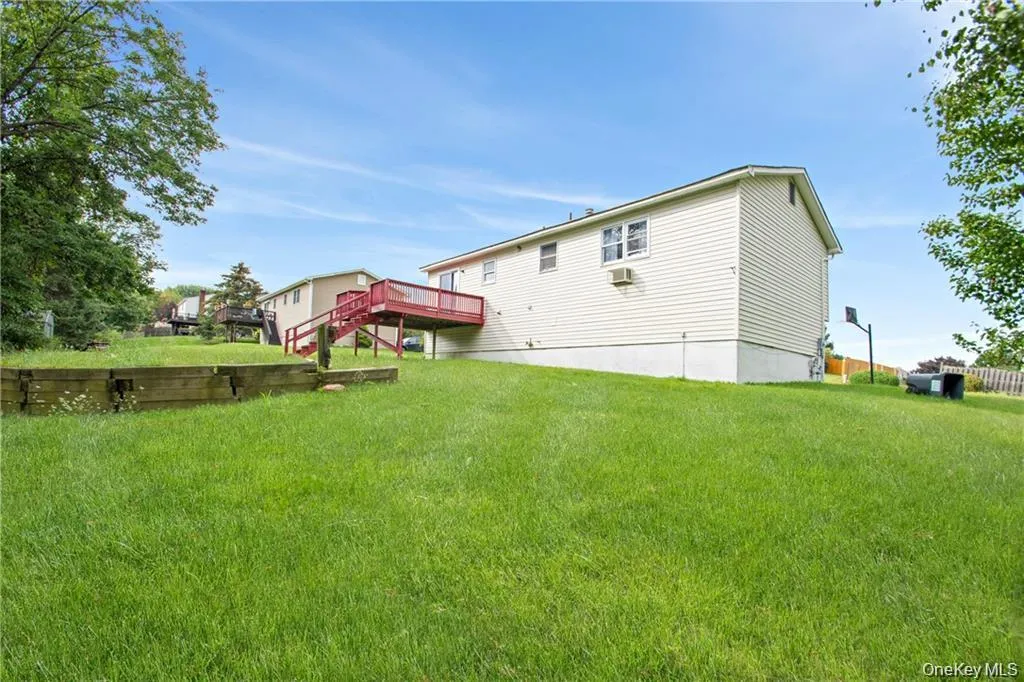 Rear view of house with a lawn and a deck Rear view of house with a lawn and a deck