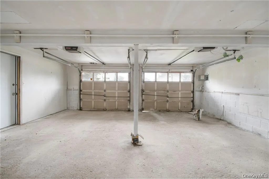 Garage featuring concrete block wall and a garage door opener Garage featuring concrete block wall and a garage door opener