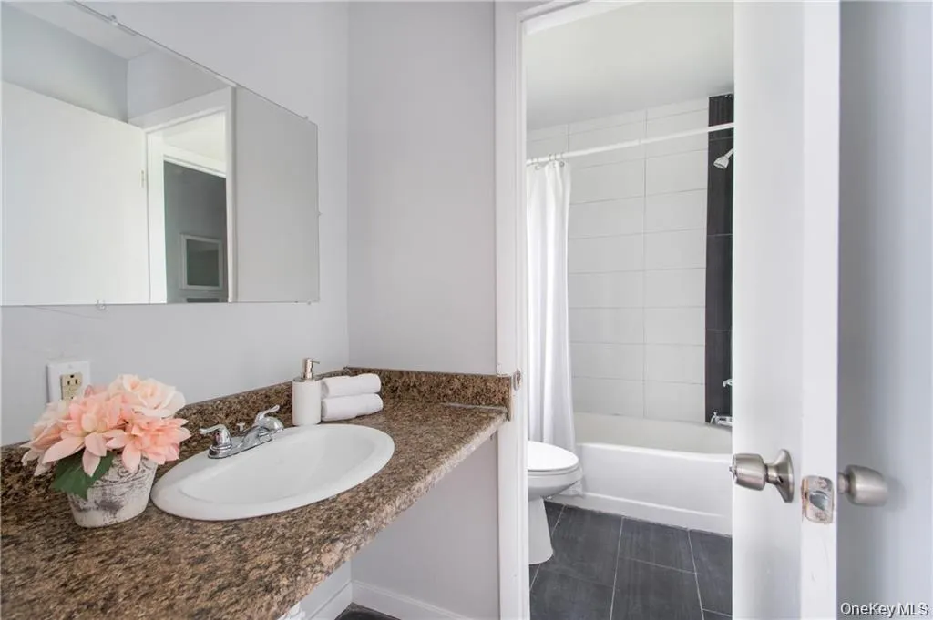 Full bathroom featuring shower / bathtub combination with curtain and vanity Full bathroom featuring shower / bathtub combination with curtain and vanity