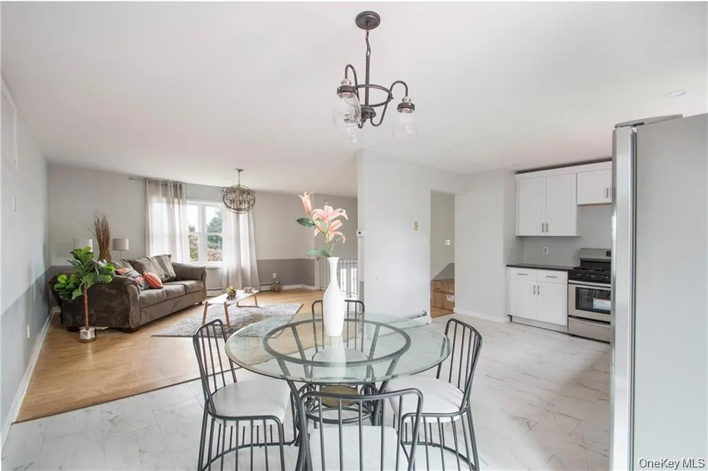 Dining room featuring a chandelier and light marble finish floors Dining room featuring a chandelier and light marble finish floors