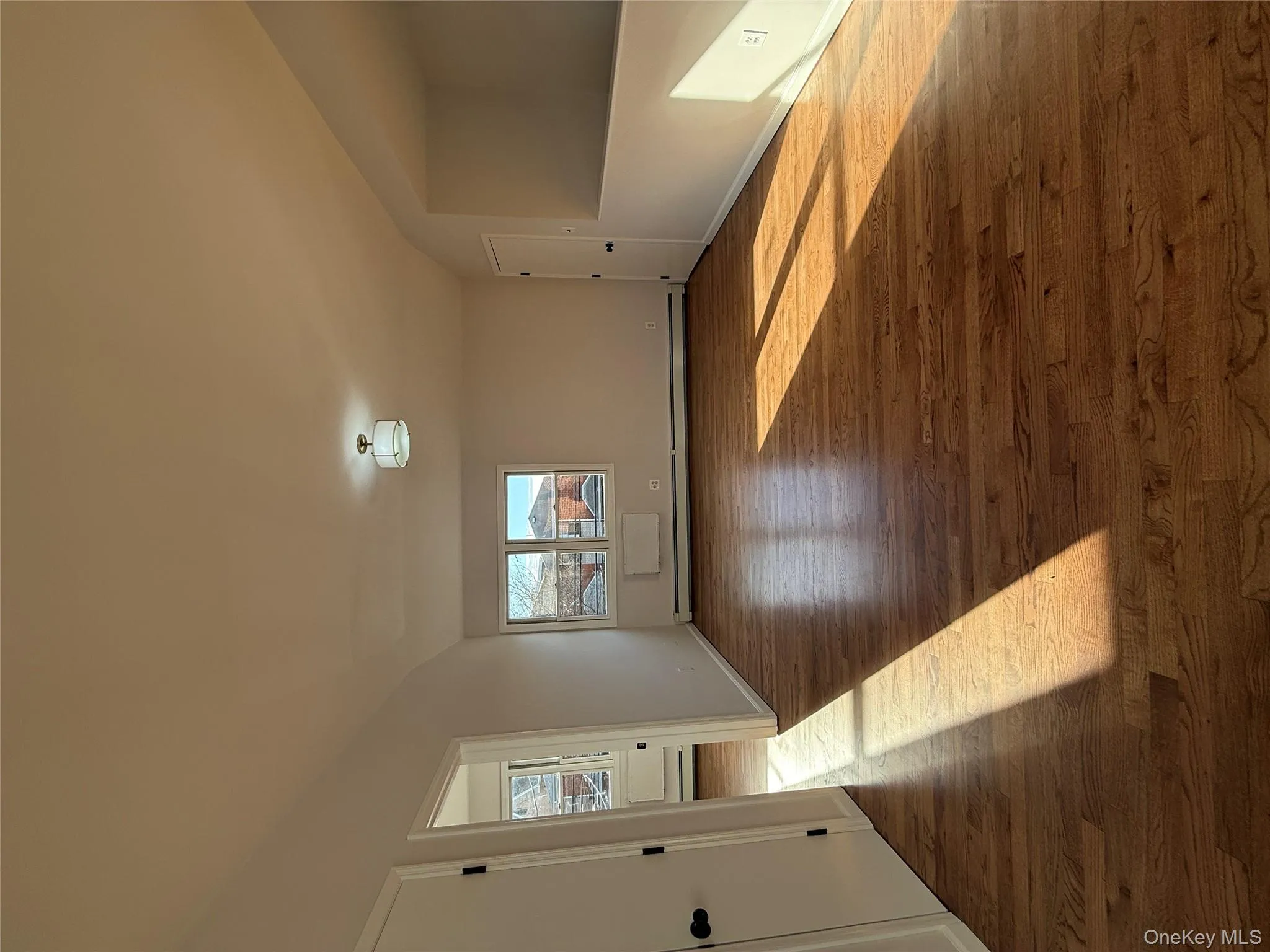 Unfurnished room featuring dark wood finished floors, baseboard heating, and vaulted ceiling Unfurnished room featuring dark wood finished floors, baseboard heating, and vaulted ceiling