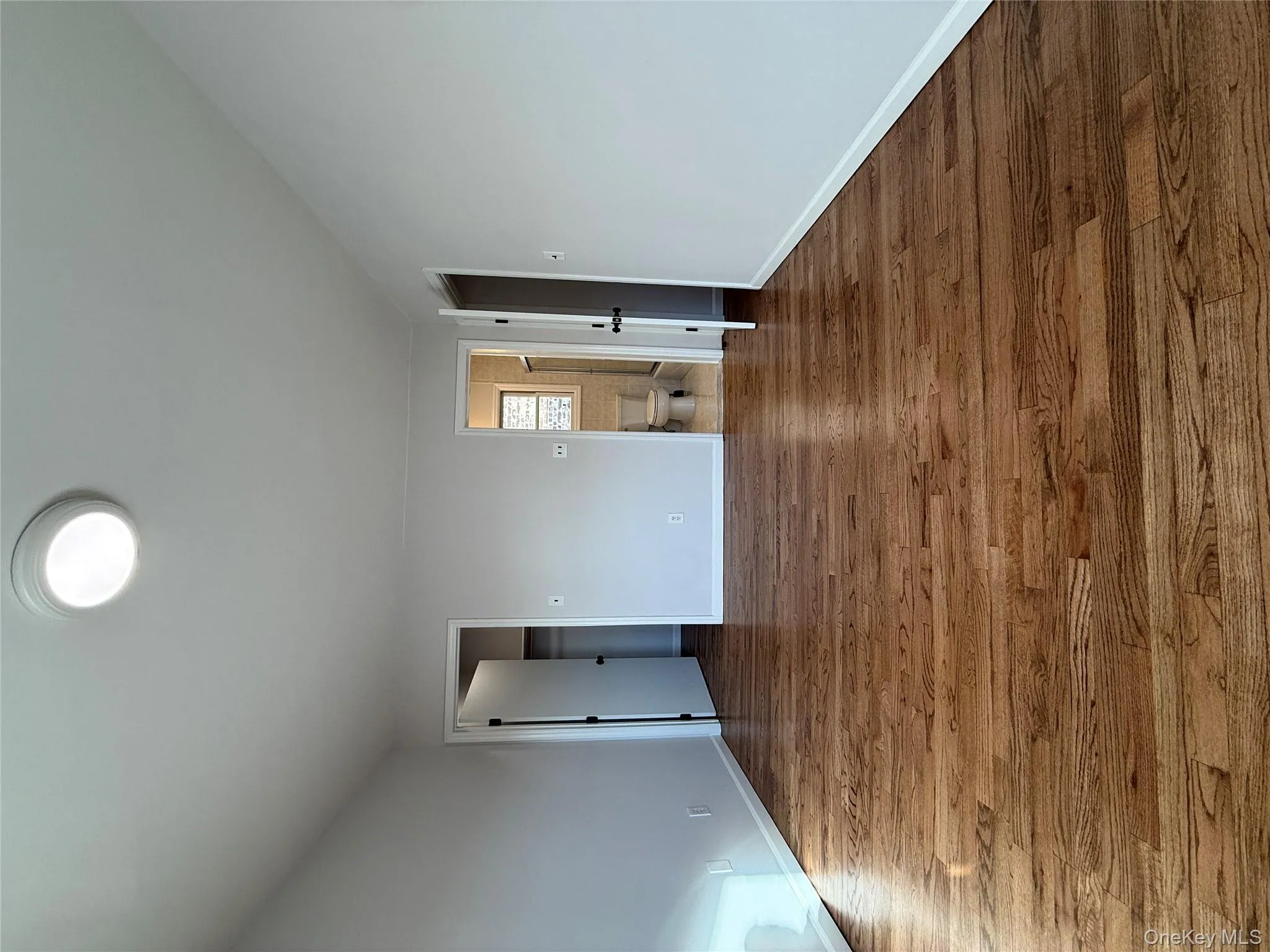 Unfurnished bedroom with a spacious closet, wood finished floors, and ensuite bathroom Unfurnished bedroom with a spacious closet, wood finished floors, and ensuite bathroom