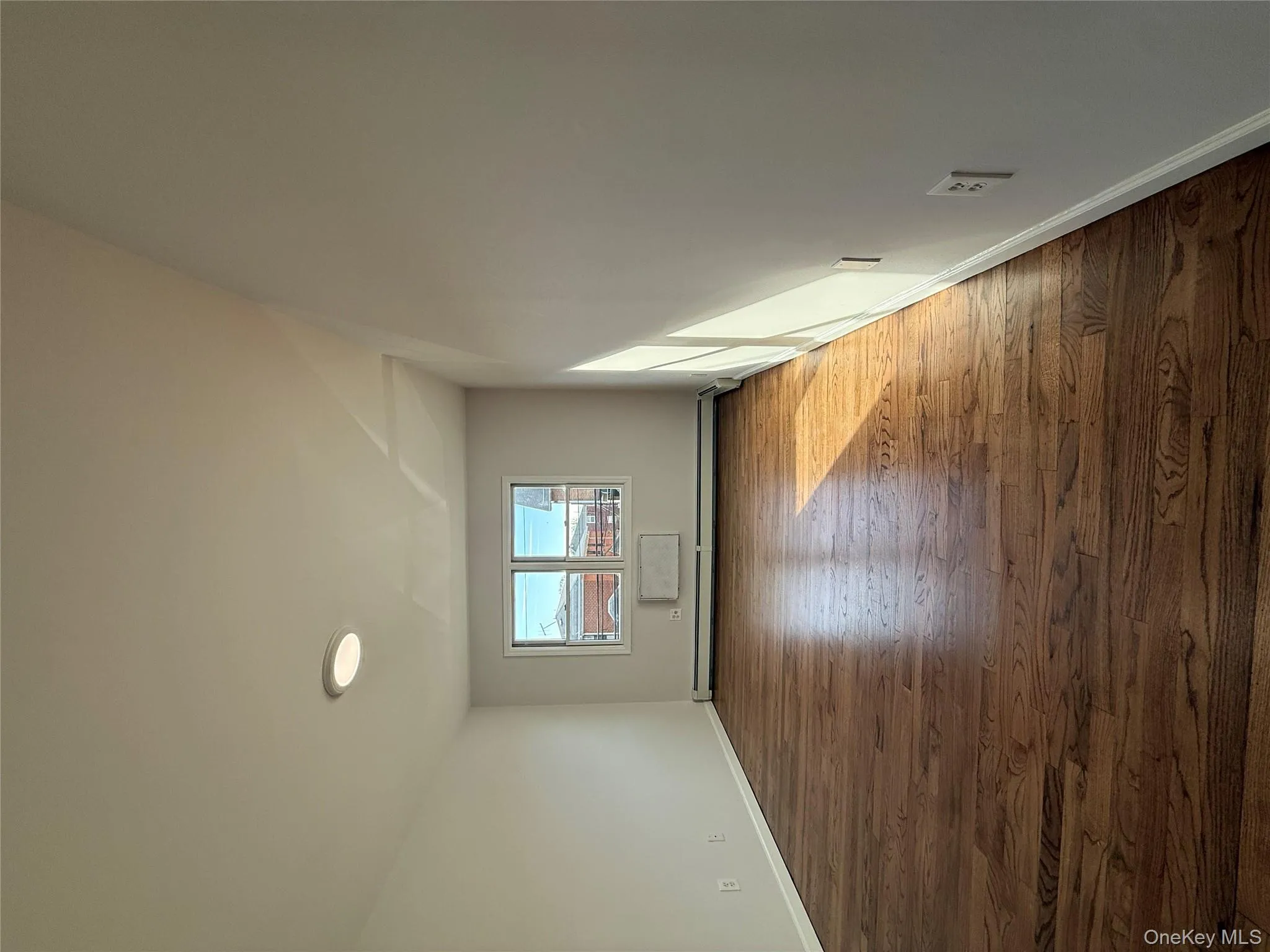 Unfurnished room featuring dark wood-type flooring and a baseboard heating unit Unfurnished room featuring dark wood-type flooring and a baseboard heating unit