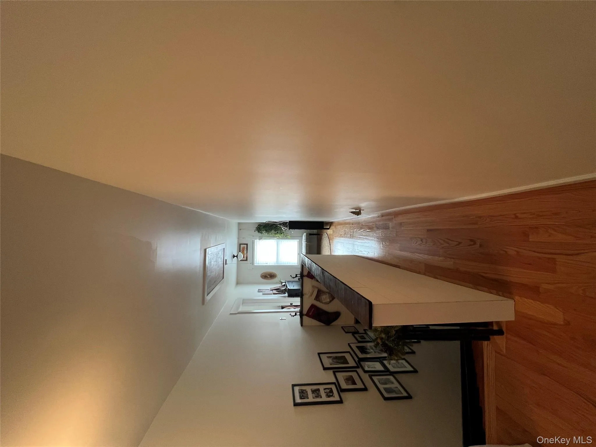 Corridor featuring attic access and light wood finished floors Corridor featuring attic access and light wood finished floors