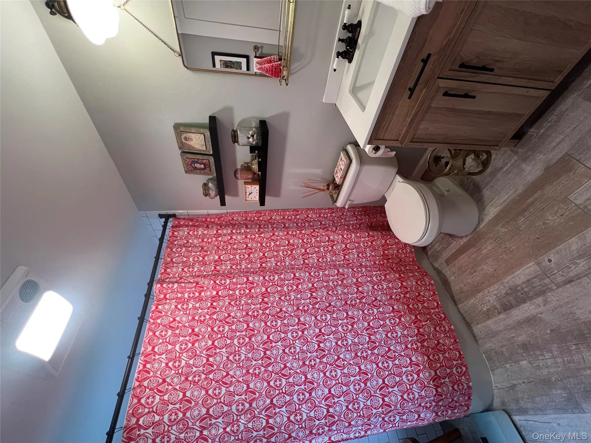 Bathroom with vanity, dark wood-type flooring, and shower / tub combo with curtain Bathroom with vanity, dark wood-type flooring, and shower / tub combo with curtain