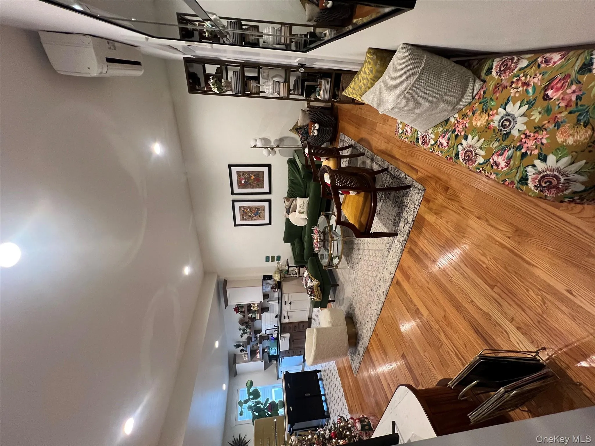 Living area featuring light wood-style floors, a wall unit AC, and recessed lighting Living area featuring light wood-style floors, a wall unit AC, and recessed lighting