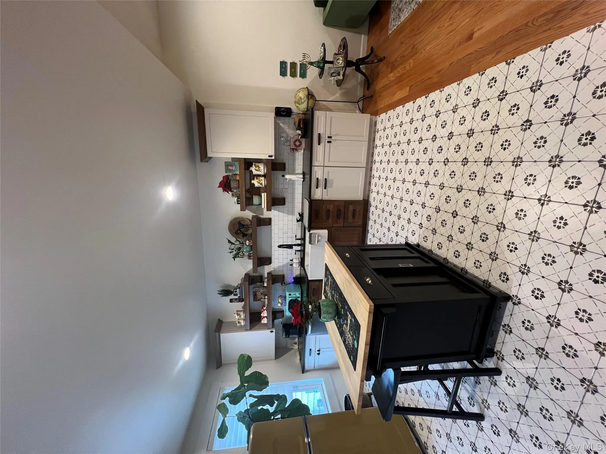 Kitchen with open shelves, dark cabinetry, fridge, a center island, and a kitchen breakfast bar Kitchen with open shelves, dark cabinetry, fridge, a center island, and a kitchen breakfast bar