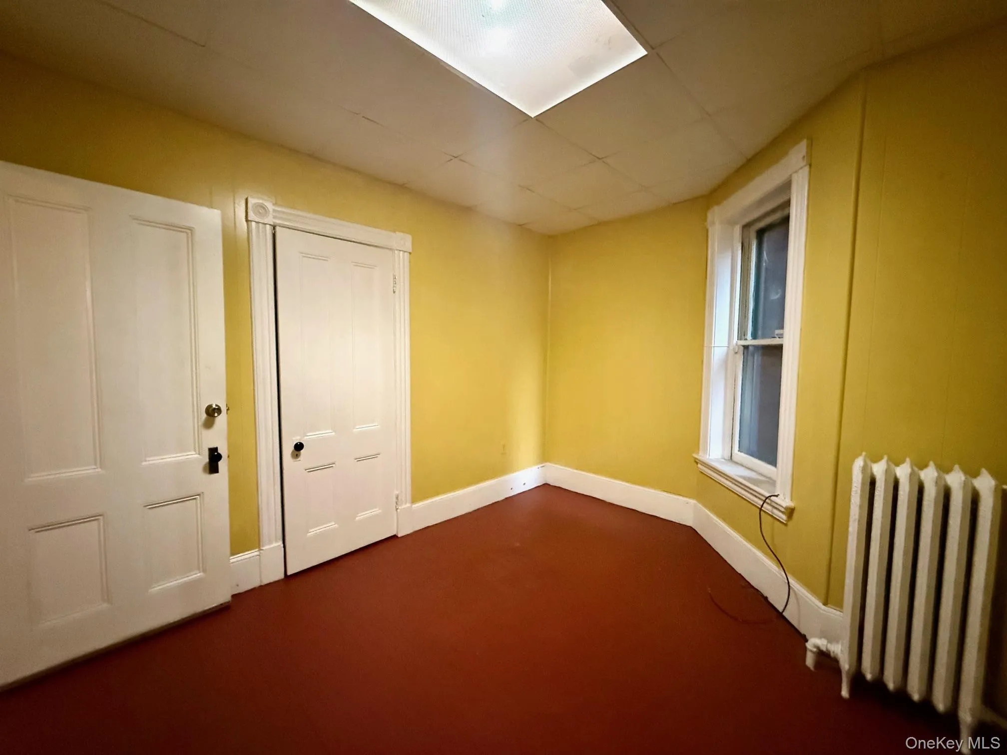 Empty room with radiator and baseboards Empty room with radiator and baseboards