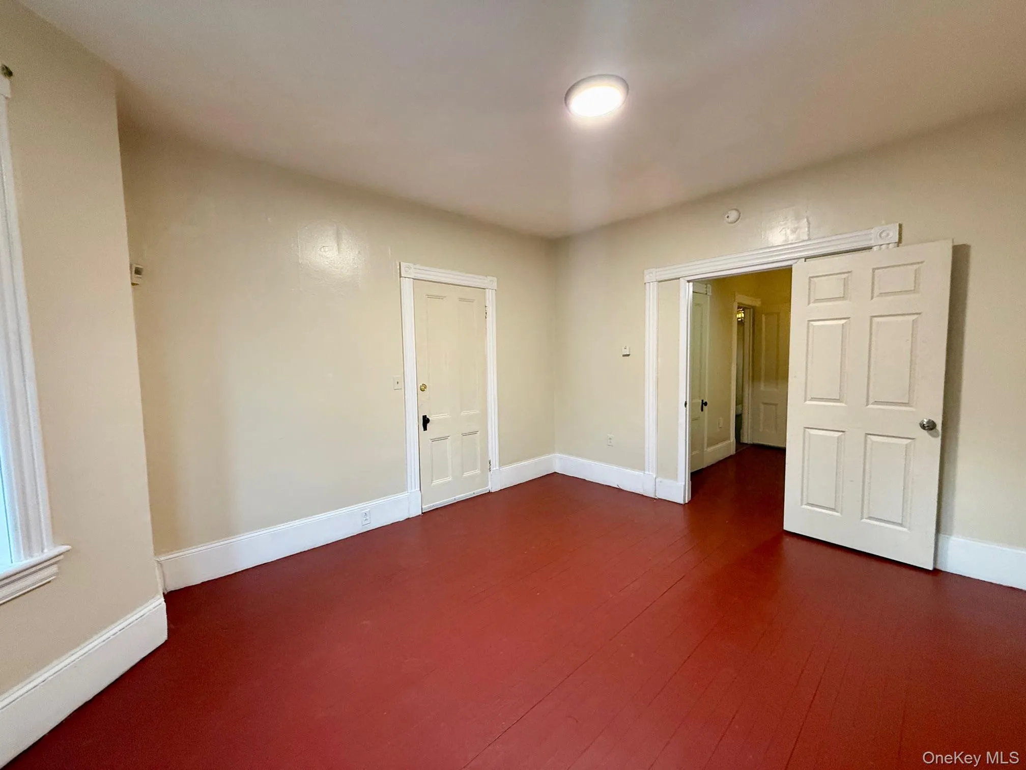 Unfurnished room with baseboards and dark wood finished floors Unfurnished room with baseboards and dark wood finished floors