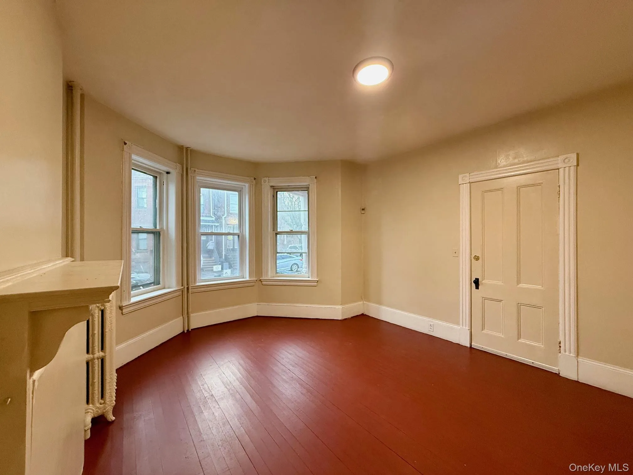 Spare room with radiator and dark wood-style floors Spare room with radiator and dark wood-style floors