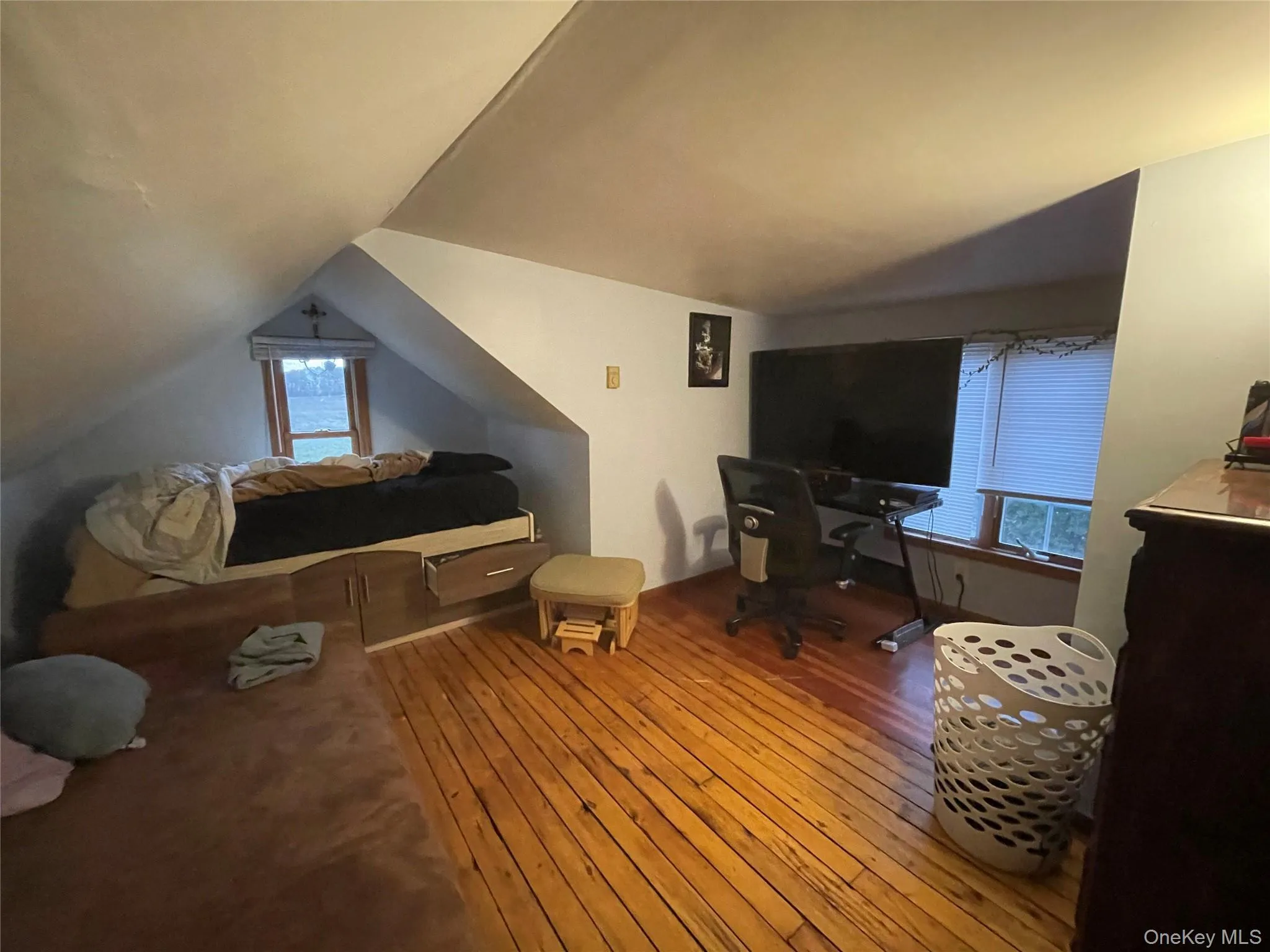 Bedroom featuring wood-type flooring, a desk, and vaulted ceiling Bedroom featuring wood-type flooring, a desk, and vaulted ceiling