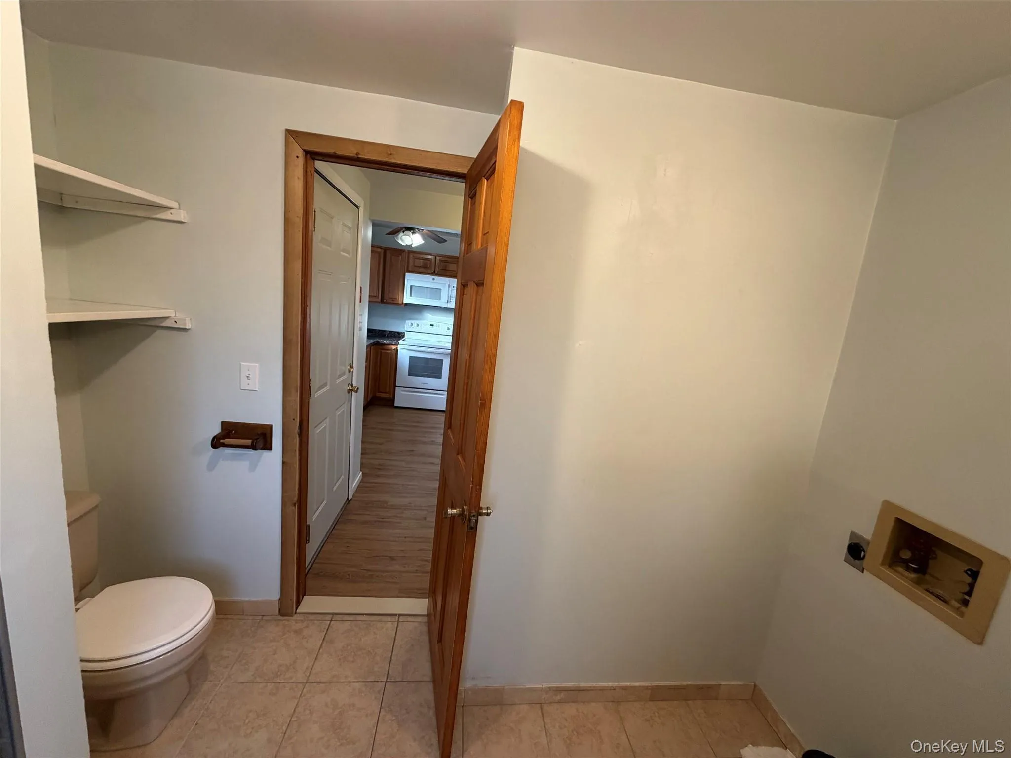 Washroom with light tile patterned flooring and washer hookup Washroom with light tile patterned flooring and washer hookup