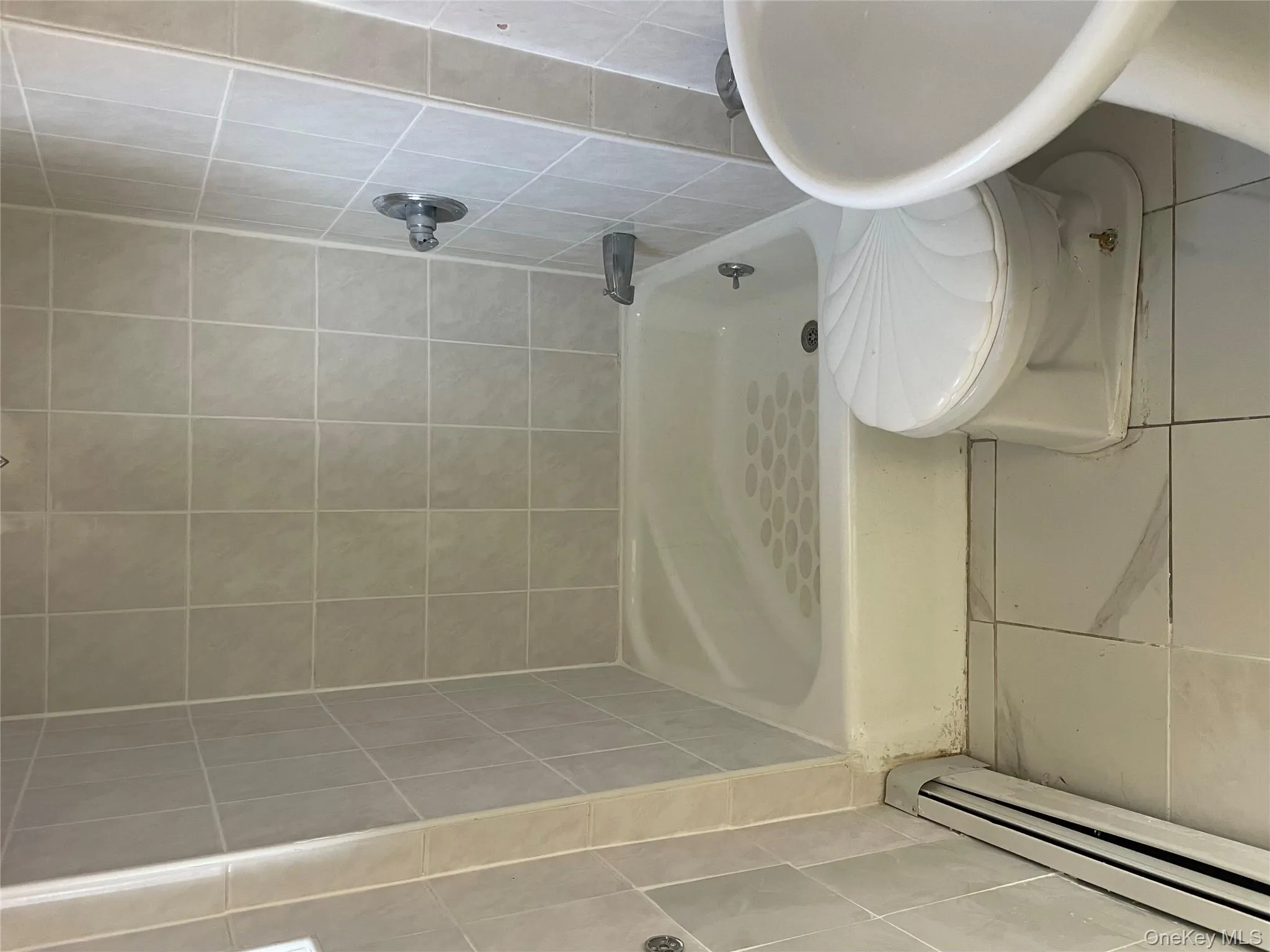 Bathroom with baseboard heating and tile patterned floors Bathroom with baseboard heating and tile patterned floors