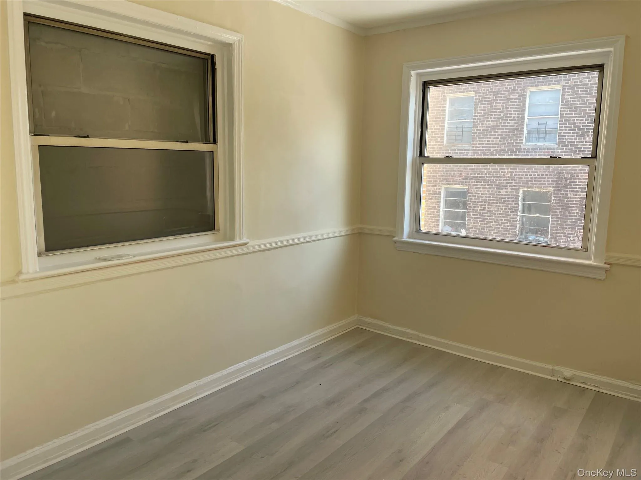 Unfurnished room with light wood-style floors and crown molding Unfurnished room with light wood-style floors and crown molding