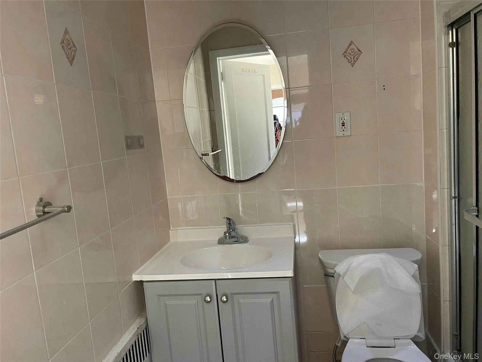 Full bathroom with vanity, tile walls, and a shower with shower door Full bathroom with vanity, tile walls, and a shower with shower door