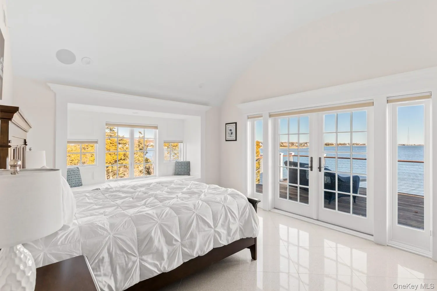 Bedroom with french doors, access to exterior, vaulted ceiling, and a water view Bedroom with french doors, access to exterior, vaulted ceiling, and a water view