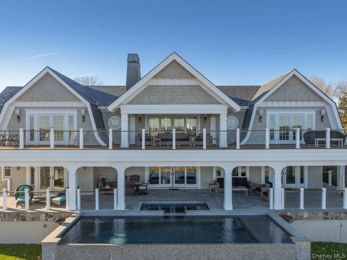 Rear view of property with a gambrel roof, french doors, and a patio area Rear view of property with a gambrel roof, french doors, and a patio area