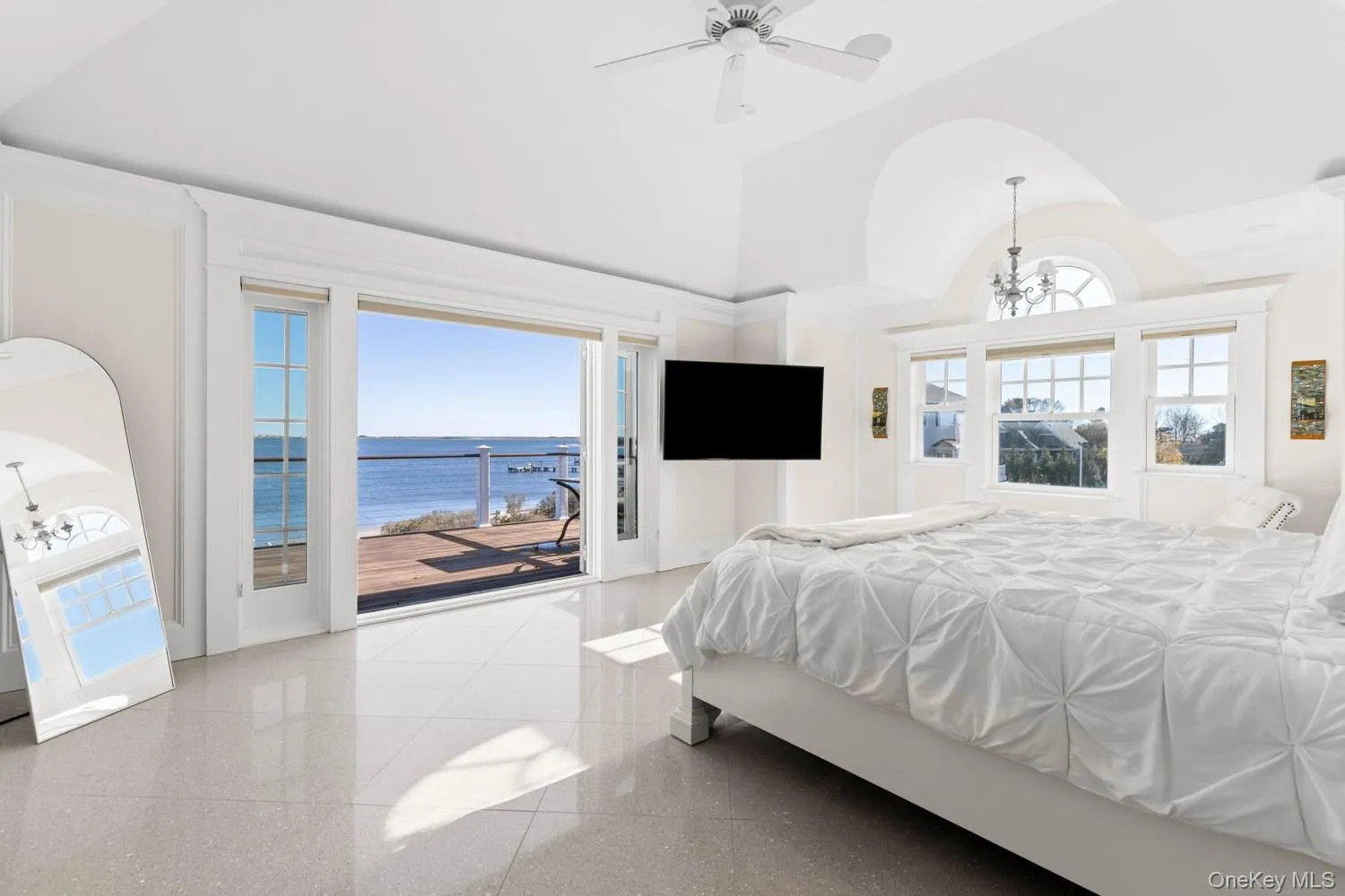 Bedroom featuring access to outside, multiple windows, a chandelier, high vaulted ceiling, and ceiling fan Bedroom featuring access to outside, multiple windows, a chandelier, high vaulted ceiling, and ceiling fan
