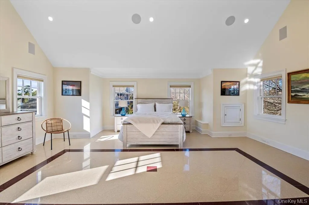 Bedroom with inlaid floor details, high vaulted ceiling, and recessed lighting Bedroom with inlaid floor details, high vaulted ceiling, and recessed lighting