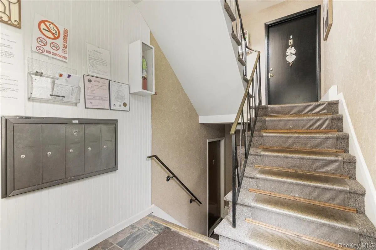 Stairway featuring stone tile floors and mail area Stairway featuring stone tile floors and mail area