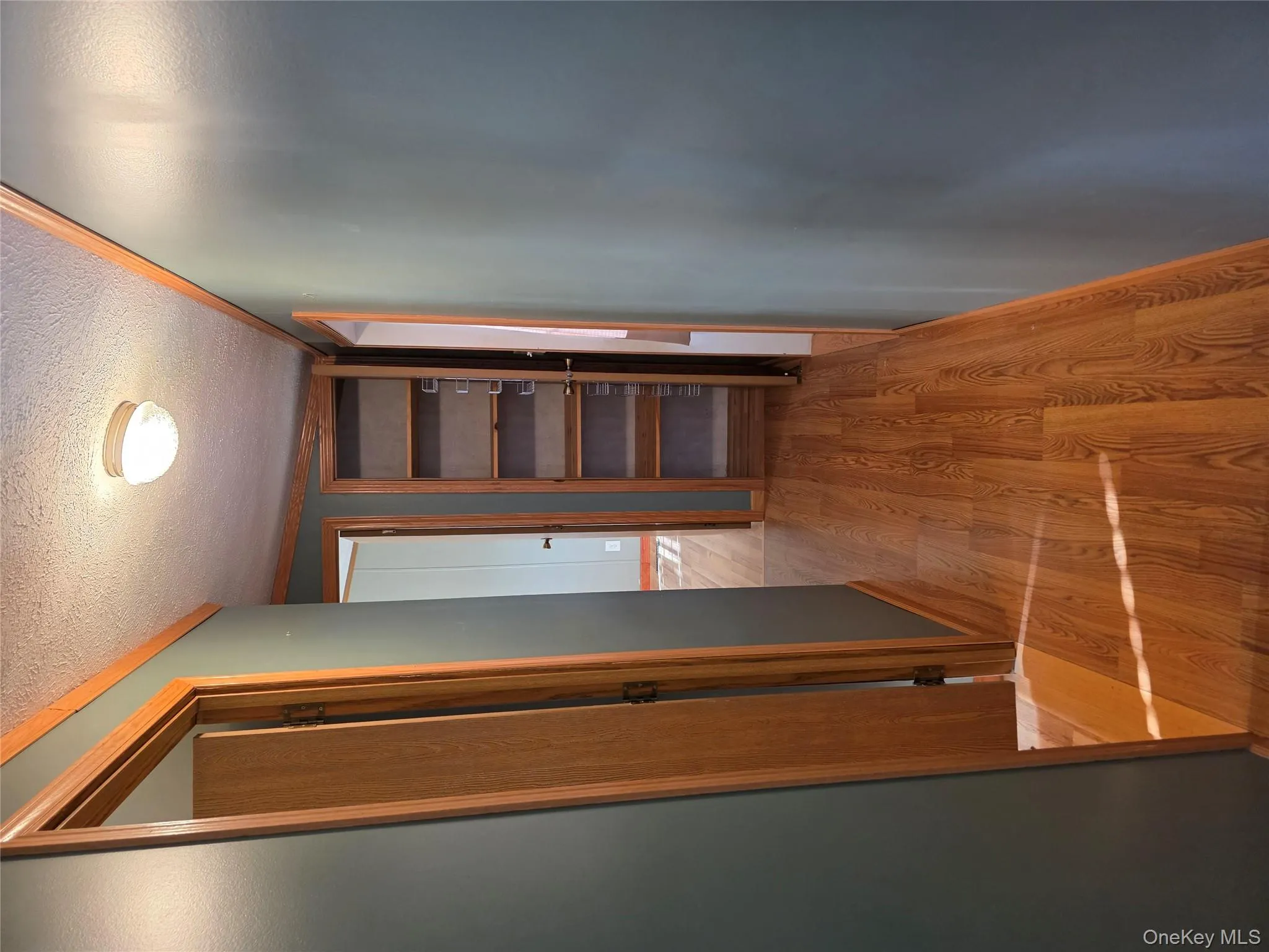 Hall featuring light wood finished floors and a textured ceiling Hall featuring light wood finished floors and a textured ceiling