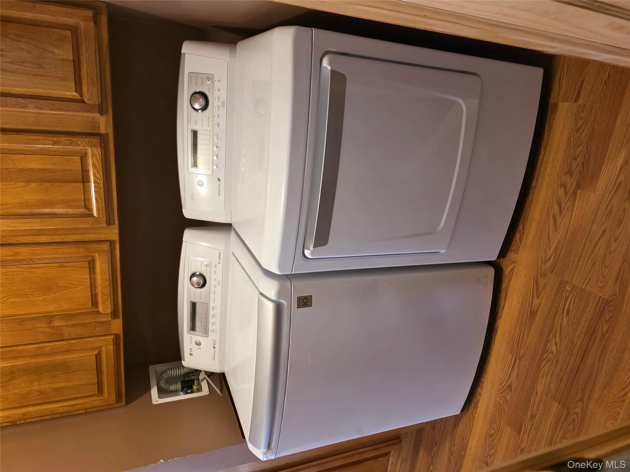 Laundry area with light wood-style floors, separate washer and dryer, and cabinet space Laundry area with light wood-style floors, separate washer and dryer, and cabinet space