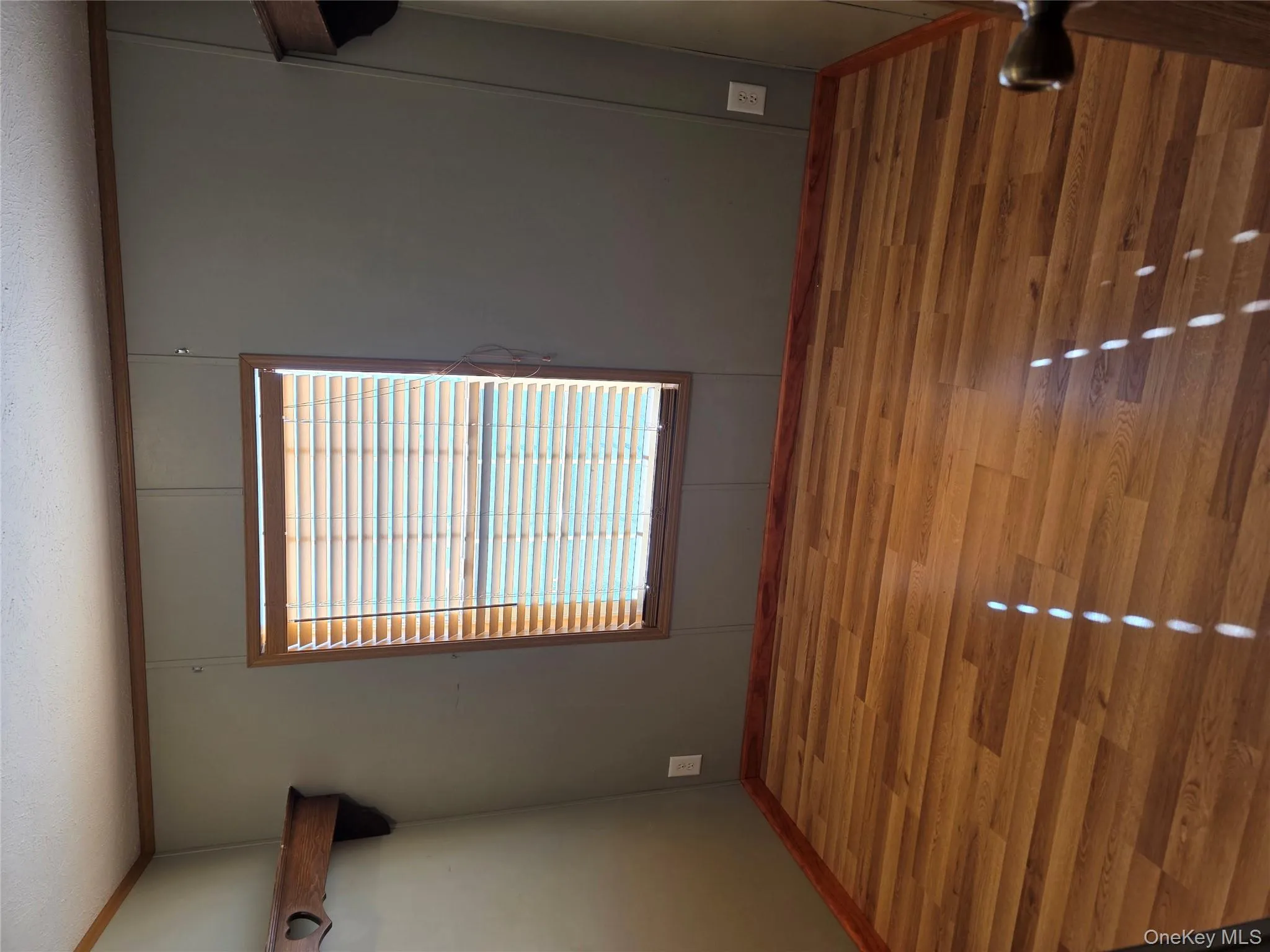 Spare room with wood finished floors, crown molding, a textured ceiling, and a decorative wall Spare room with wood finished floors, crown molding, a textured ceiling, and a decorative wall