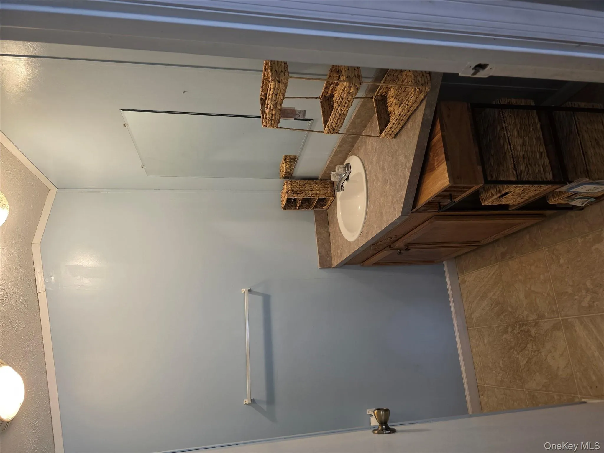 Bathroom featuring vanity, a textured ceiling, light tile patterned flooring, and crown molding Bathroom featuring vanity, a textured ceiling, light tile patterned flooring, and crown molding