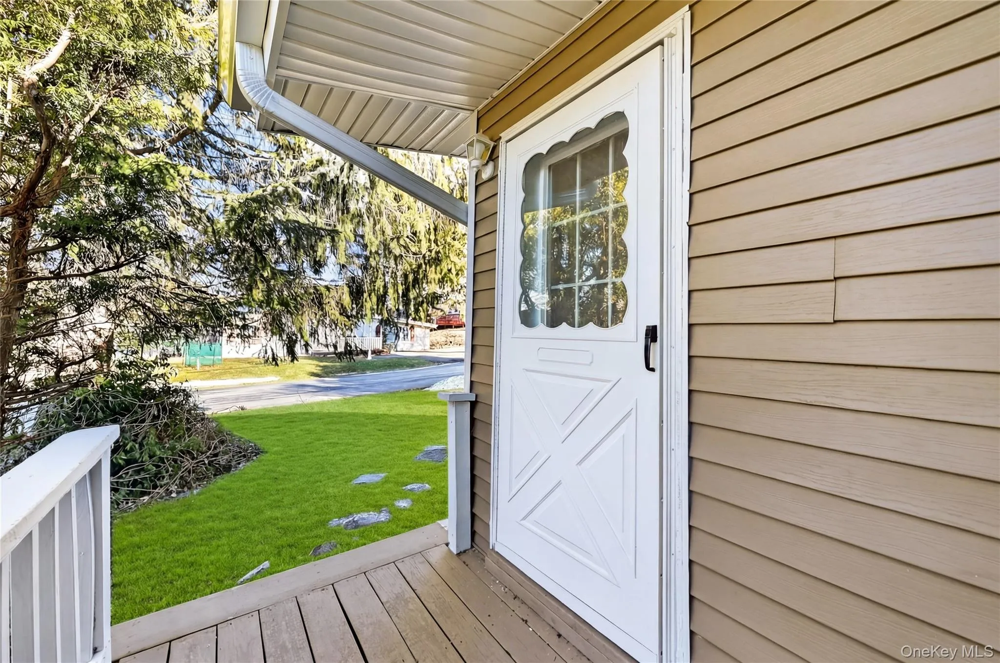 Property entrance featuring a yard and a deck Property entrance featuring a yard and a deck