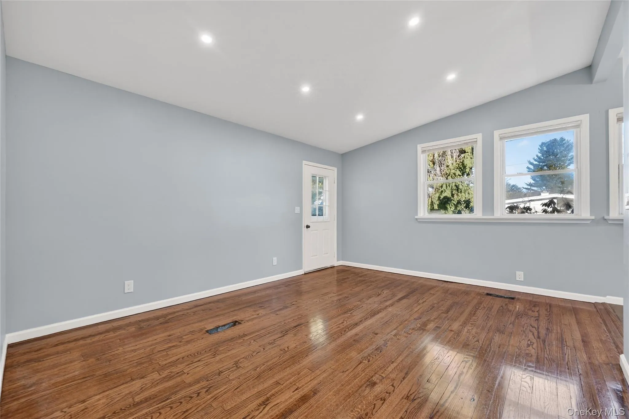 Spare room with lofted ceiling, hardwood / wood-style floors, and recessed lighting Spare room with lofted ceiling, hardwood / wood-style floors, and recessed lighting
