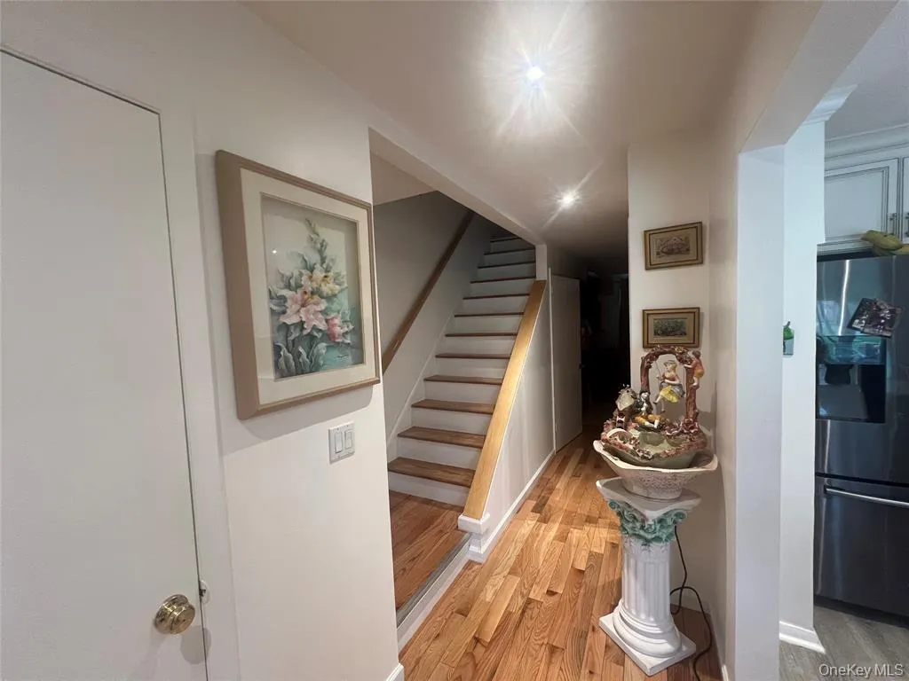 Hallway with light wood-style flooring and stairway Hallway with light wood-style flooring and stairway