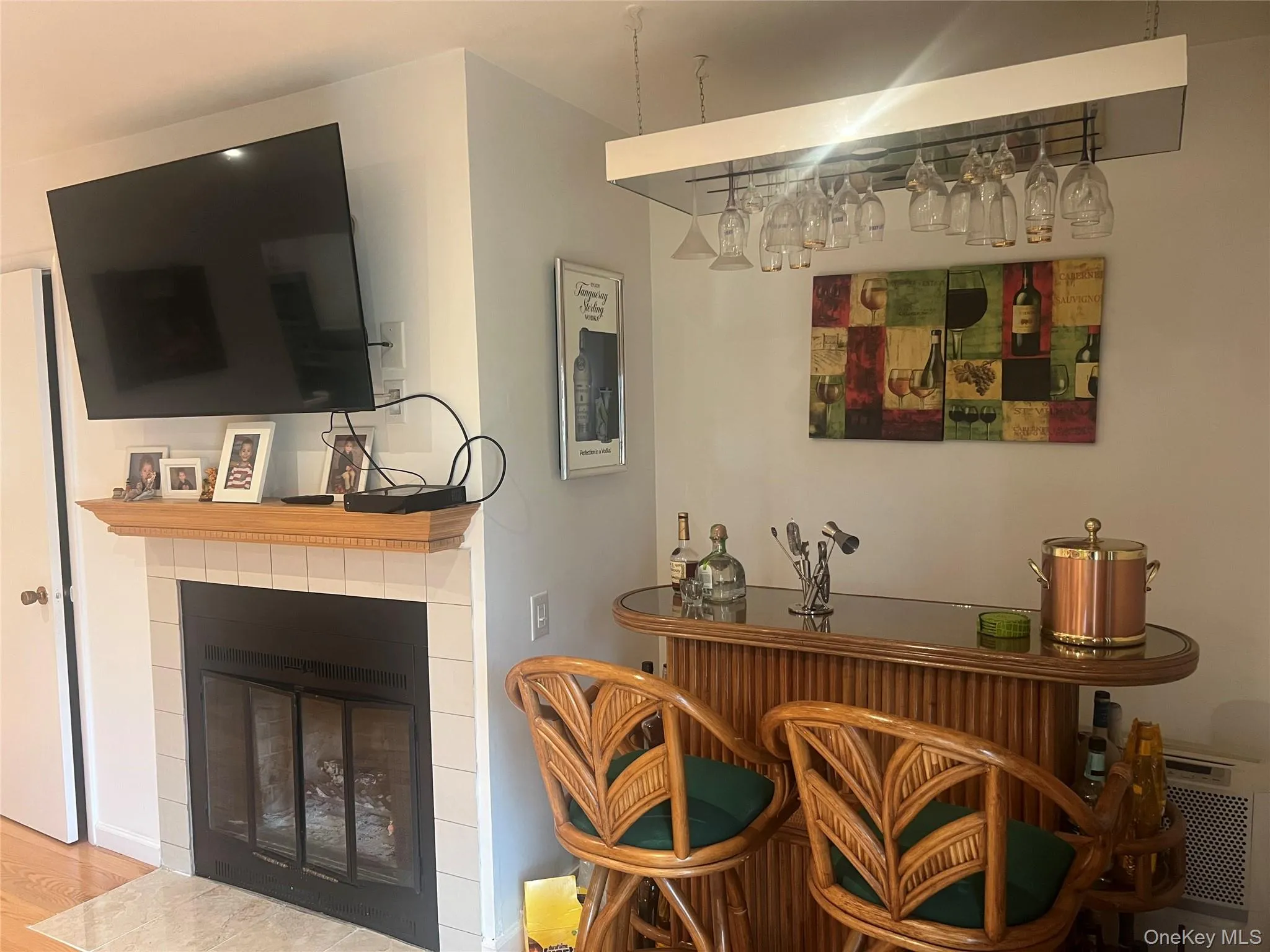 Indoor dry bar featuring a fireplace and wood finished floors Indoor dry bar featuring a fireplace and wood finished floors